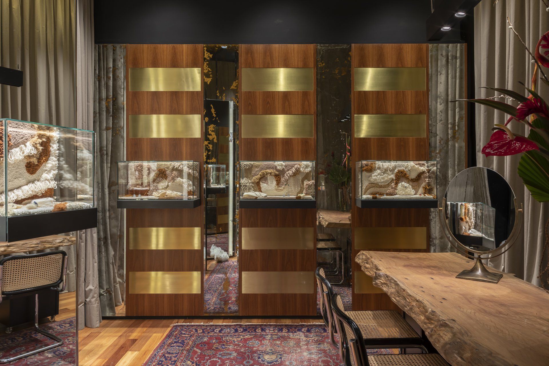 Uma joalheria com portas de correr, mesa, cadeiras e espelho.