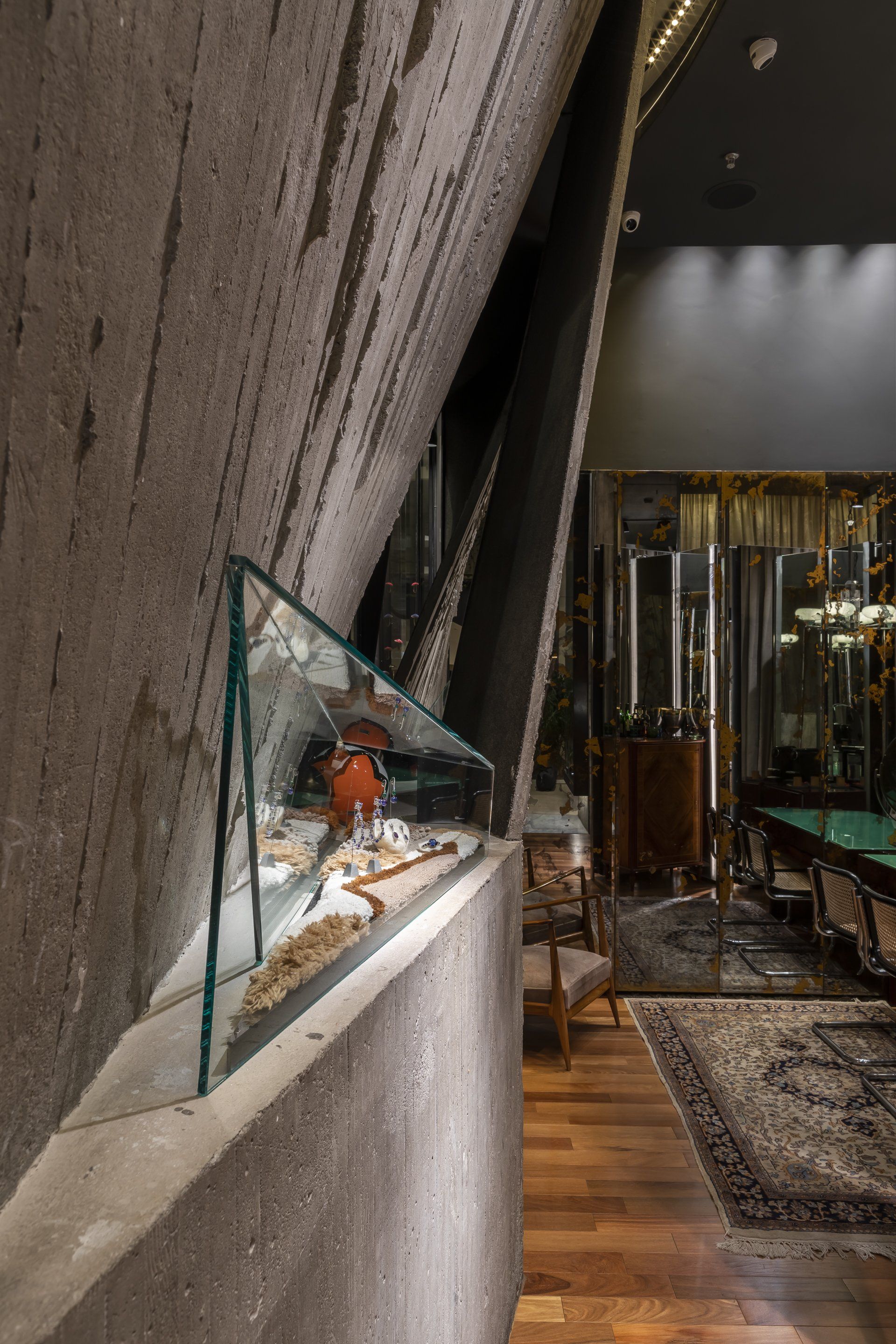 Há uma vitrine de vidro no meio da sala.