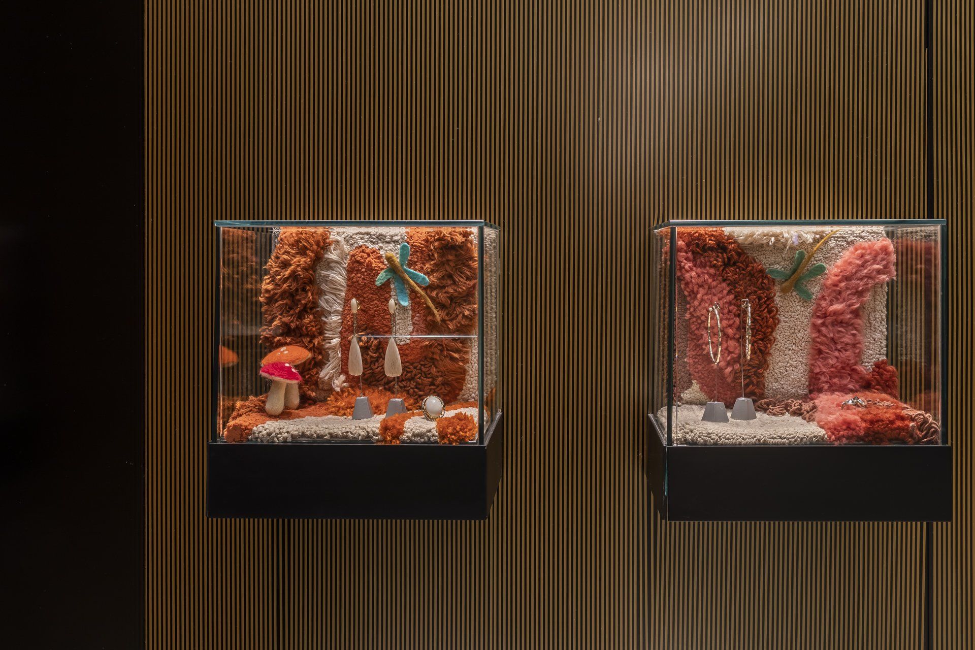 Duas vitrines cheias de vários objetos estão penduradas na parede.