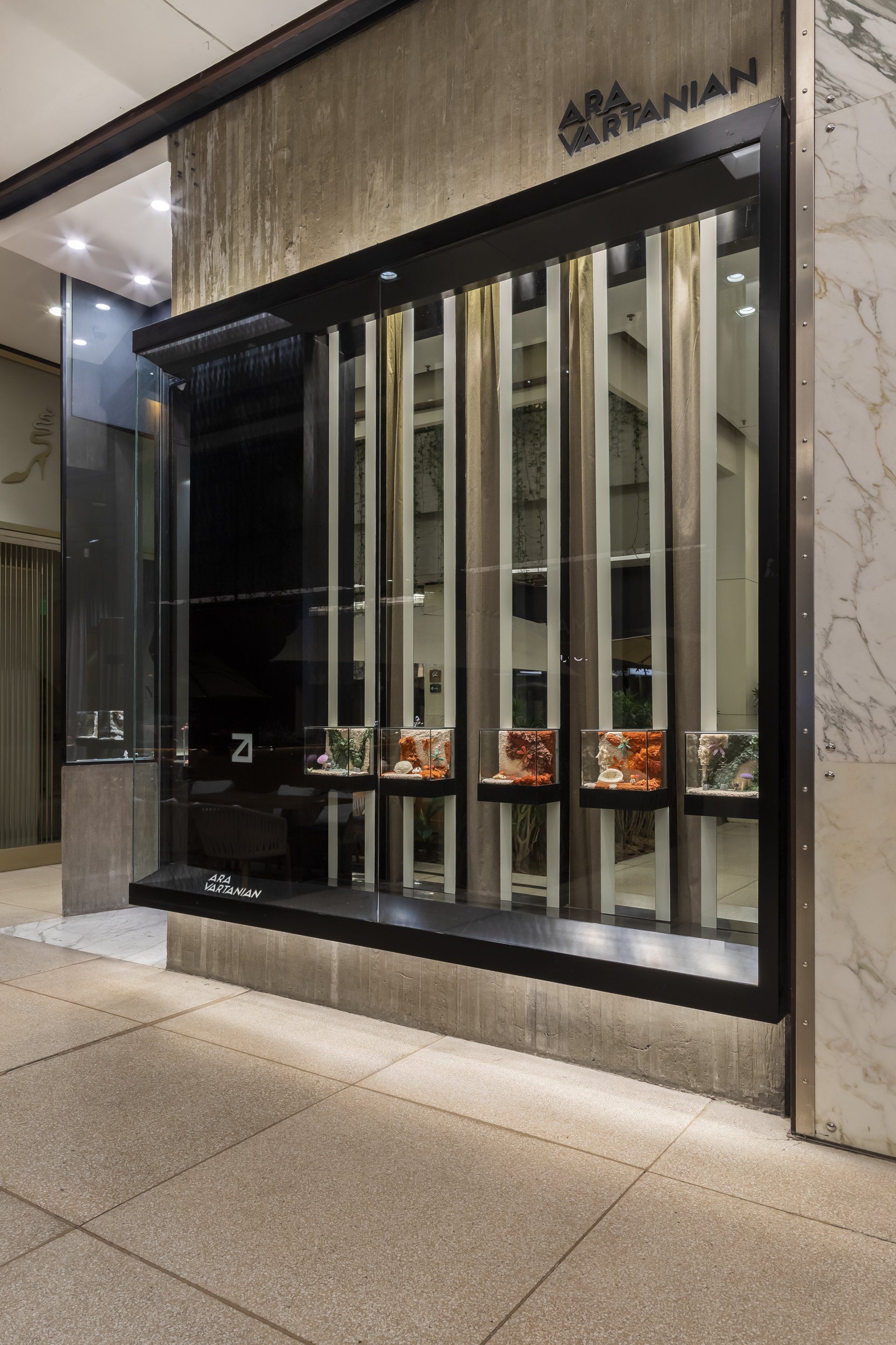 Fachada de loja com exposição de sapatos em uma vitrine.