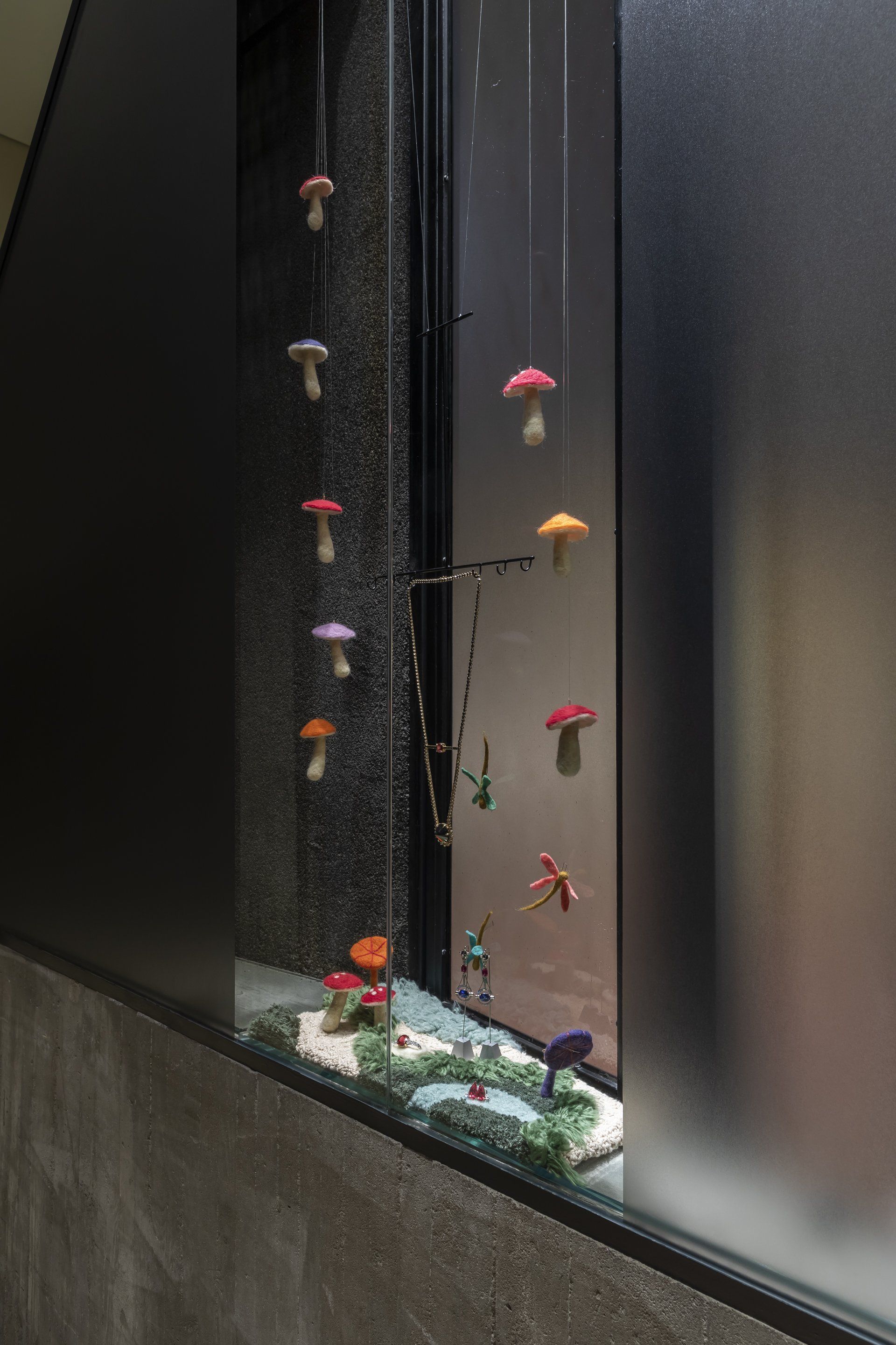 Uma janela com um colar de cogumelos pendurados.