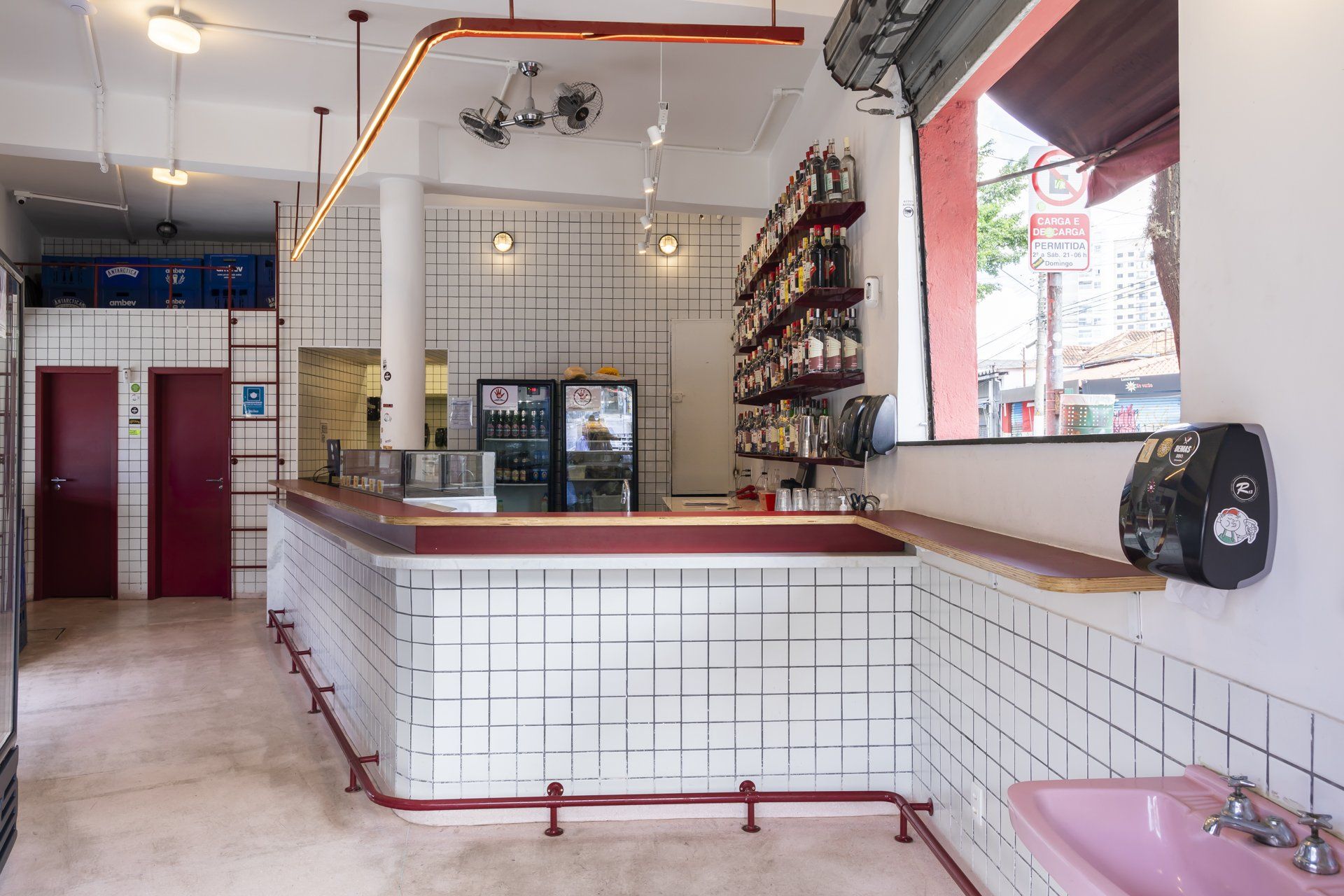 Um restaurante com um balcão comprido e uma pia rosa.