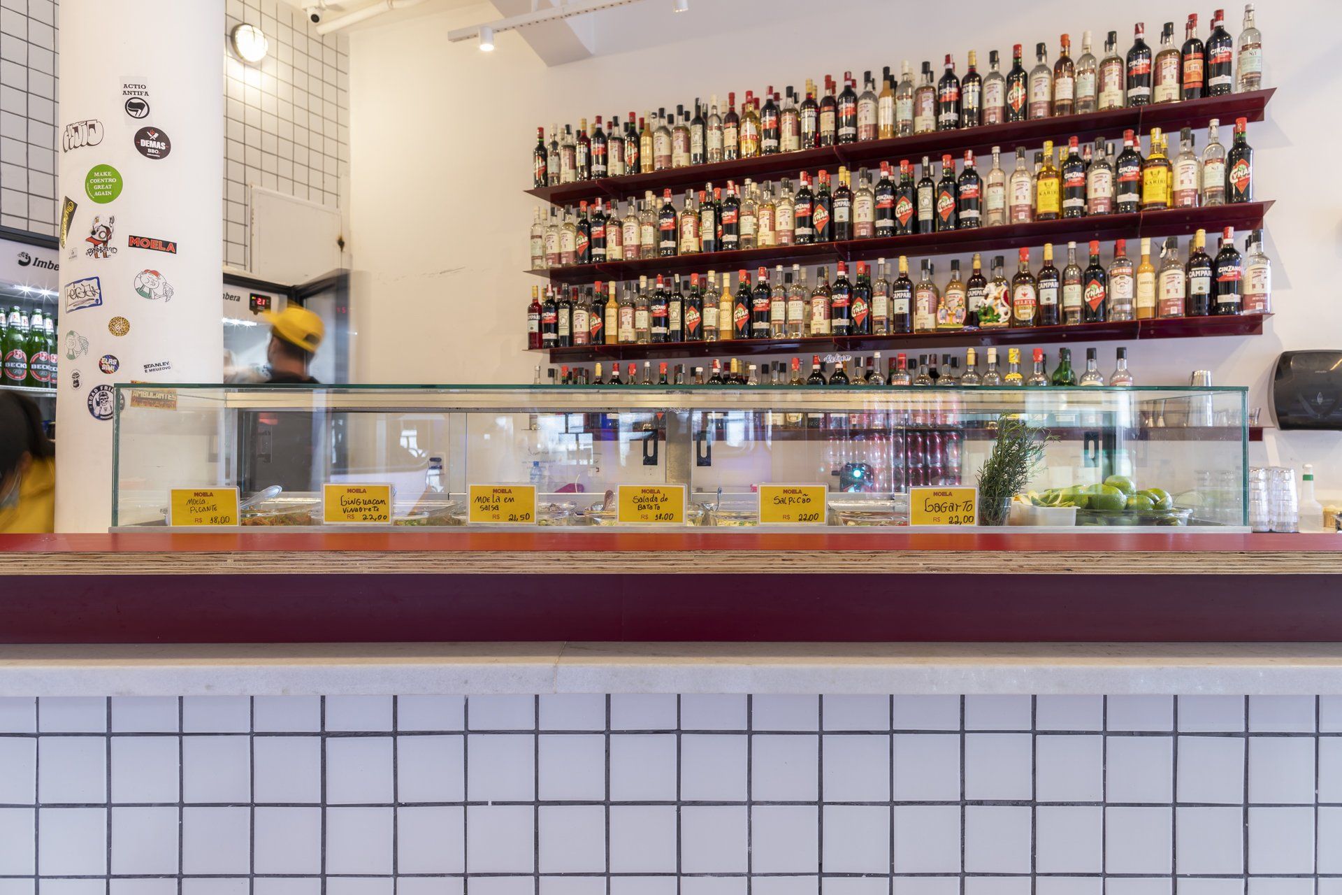 Um restaurante com uma vitrine cheia de garrafas de álcool.