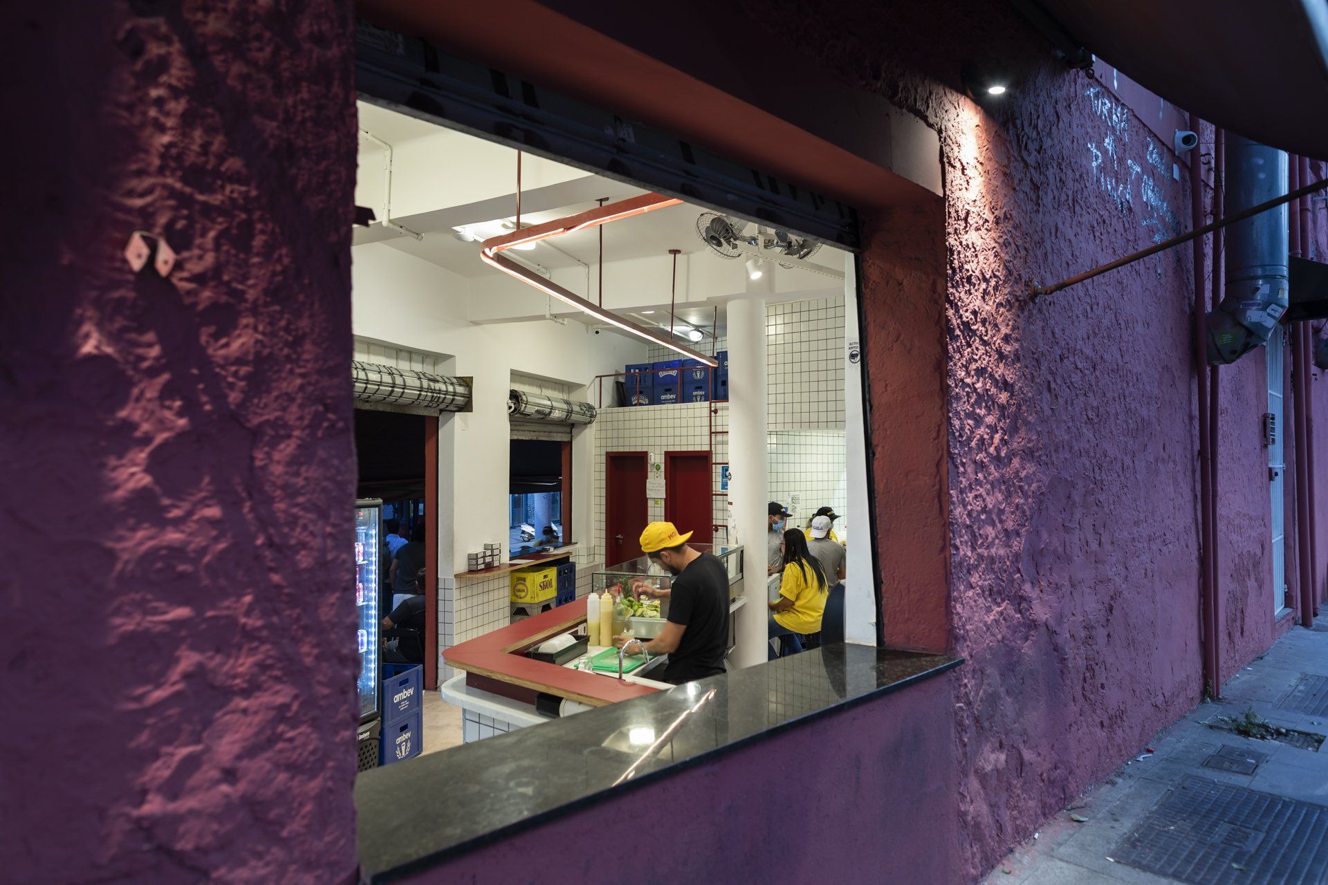 Um homem está sentado à mesa em frente à janela de um restaurante.