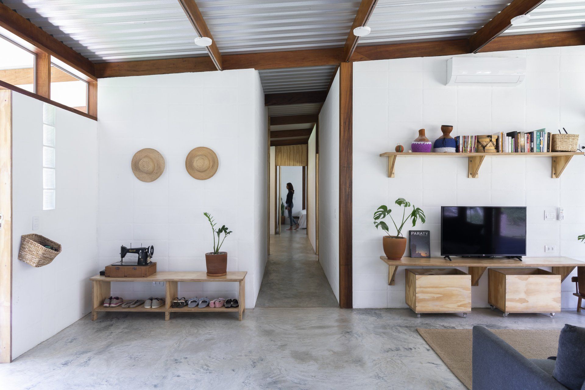 Uma sala de estar com máquina de costura e TV de tela plana