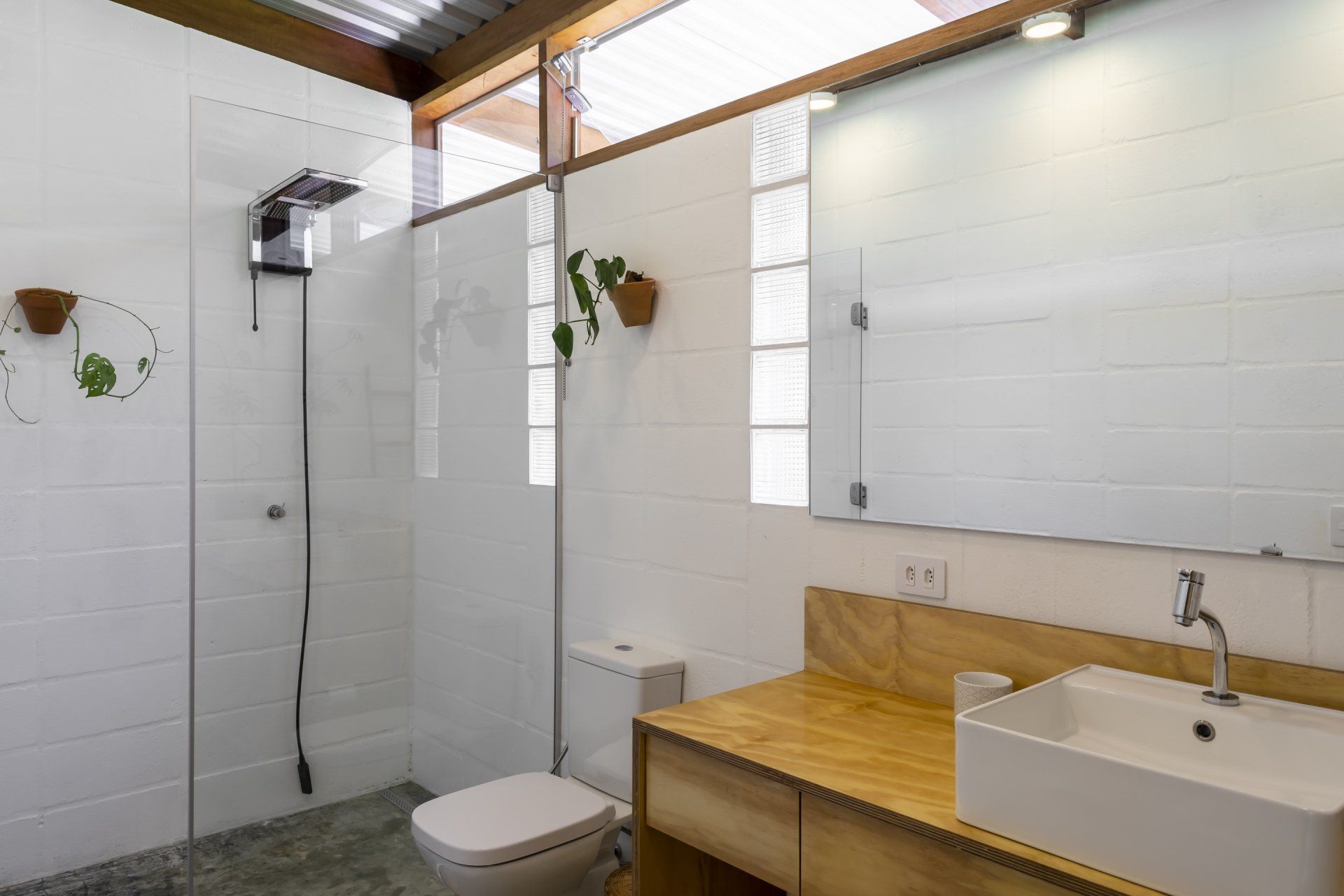 Um banheiro com vaso sanitário, pia e chuveiro.