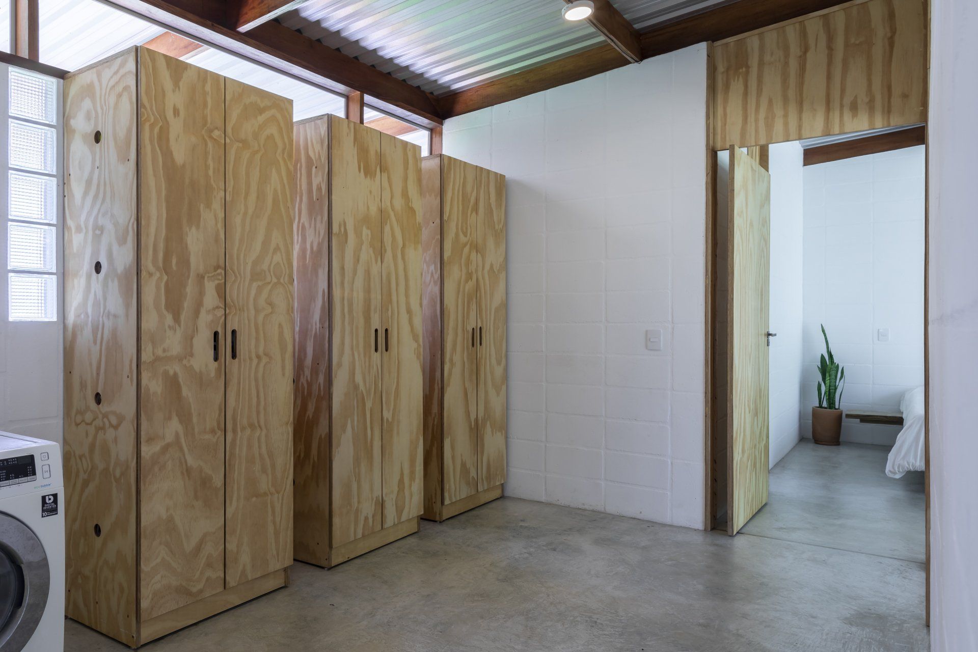 Uma lavanderia com armários de madeira e máquina de lavar e secar roupa.