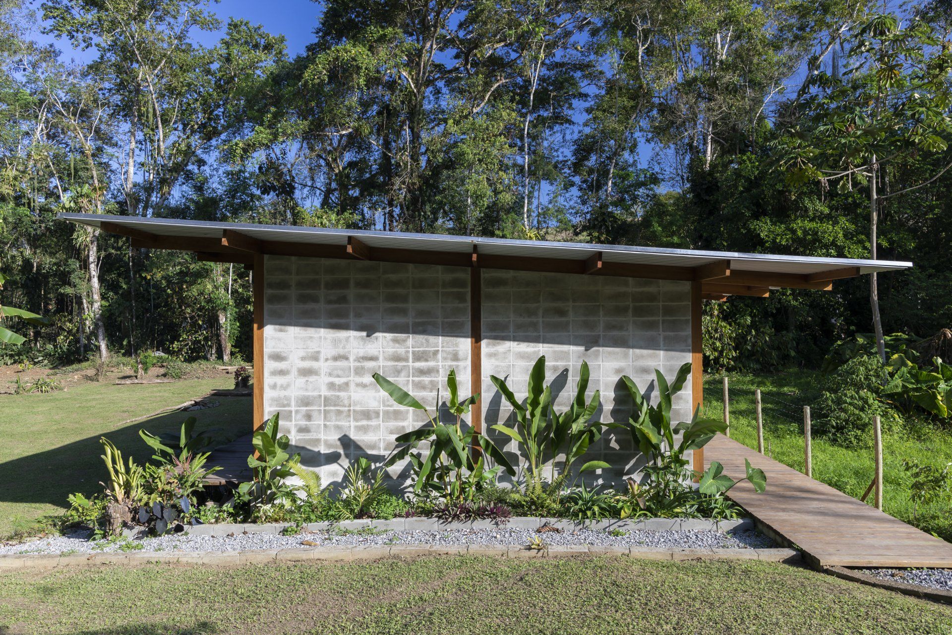 Uma pequena casa no meio de um campo com árvores ao fundo