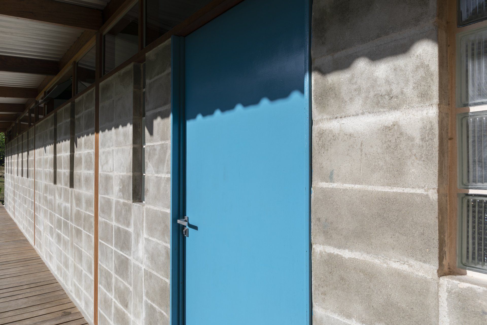 Uma porta azul está na lateral de um prédio de tijolos.