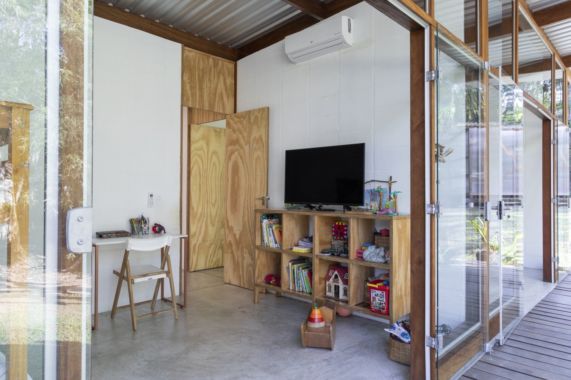 Uma sala com uma escrivaninha e uma televisão.