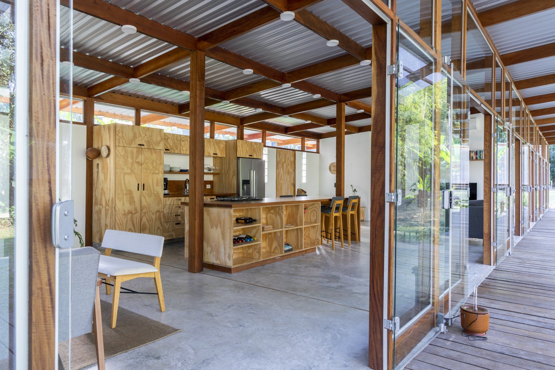 Uma sala grande com muitas janelas e pilares de madeira.