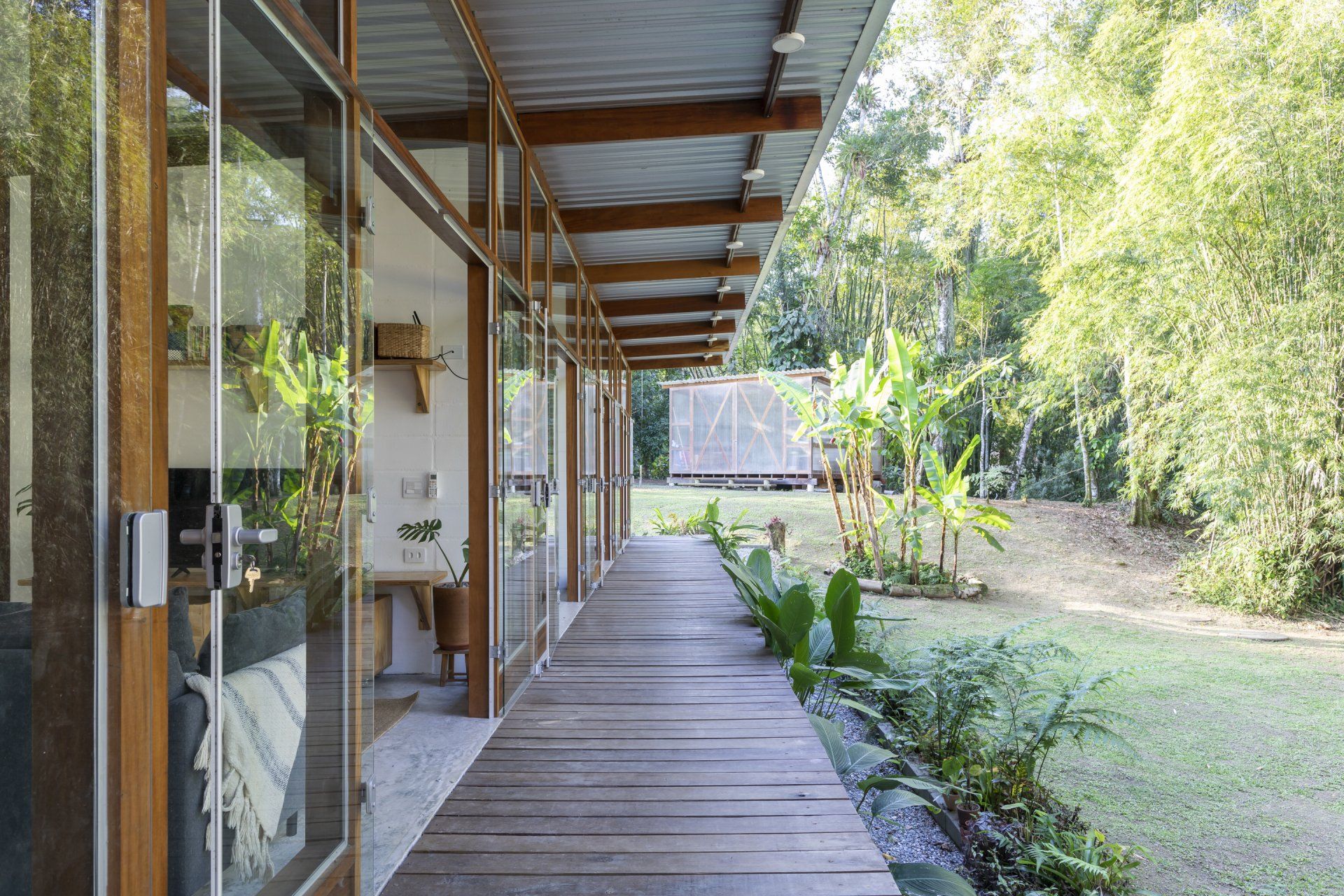 Uma longa passarela de madeira que leva a uma casa na floresta.
