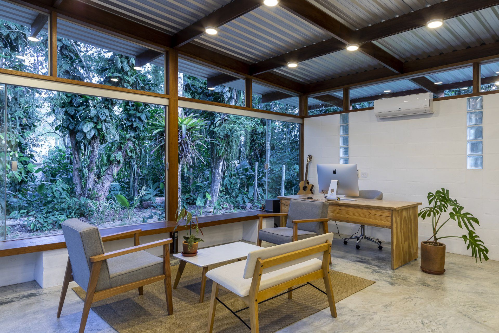 Uma sala de estar com escrivaninha, cadeiras e uma mesa.