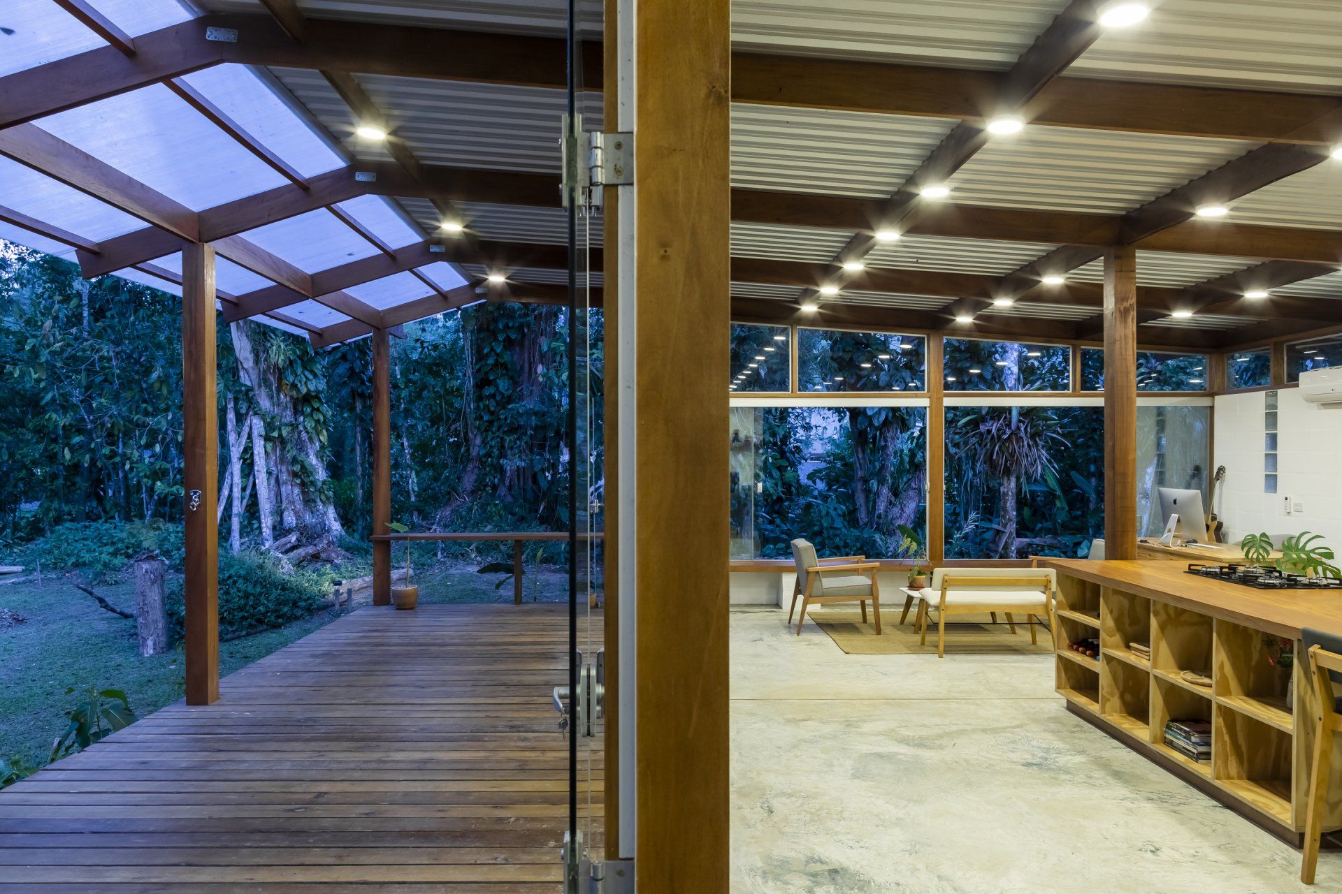 Uma sala grande com muitas janelas e piso de madeira.