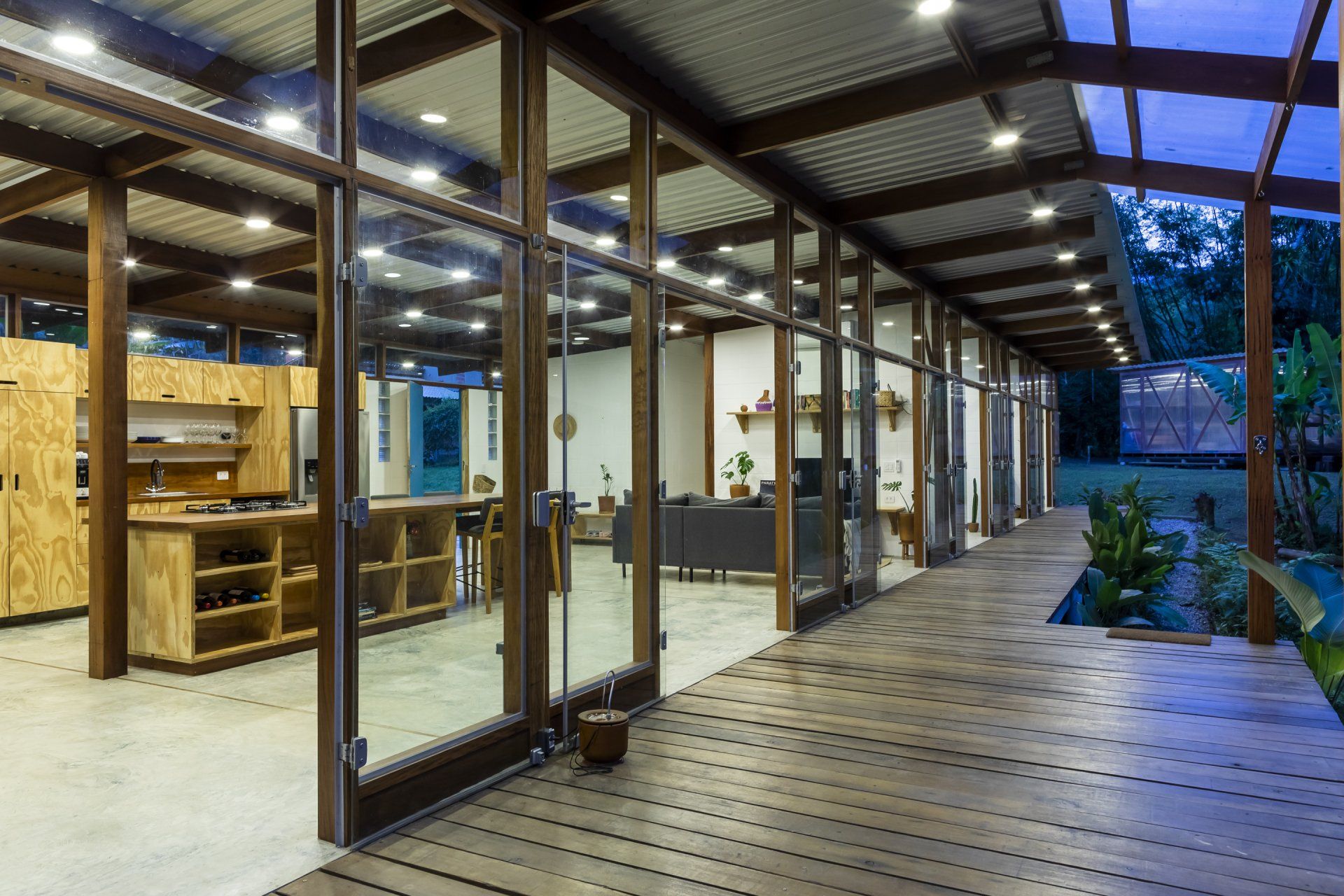 Uma casa grande com muitas janelas e deck de madeira.