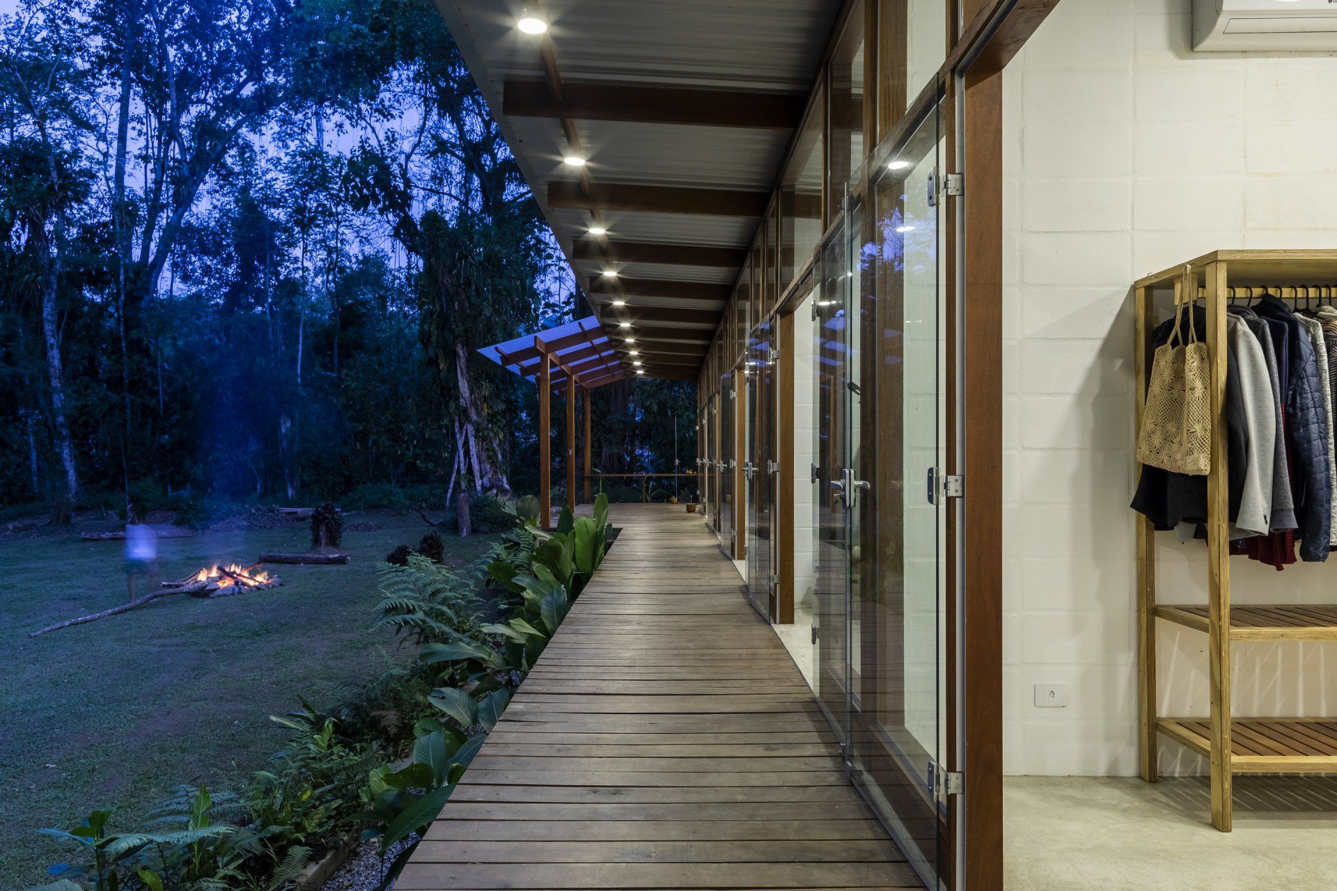 Uma longa passarela de madeira que leva a uma fogueira no quintal de uma casa.