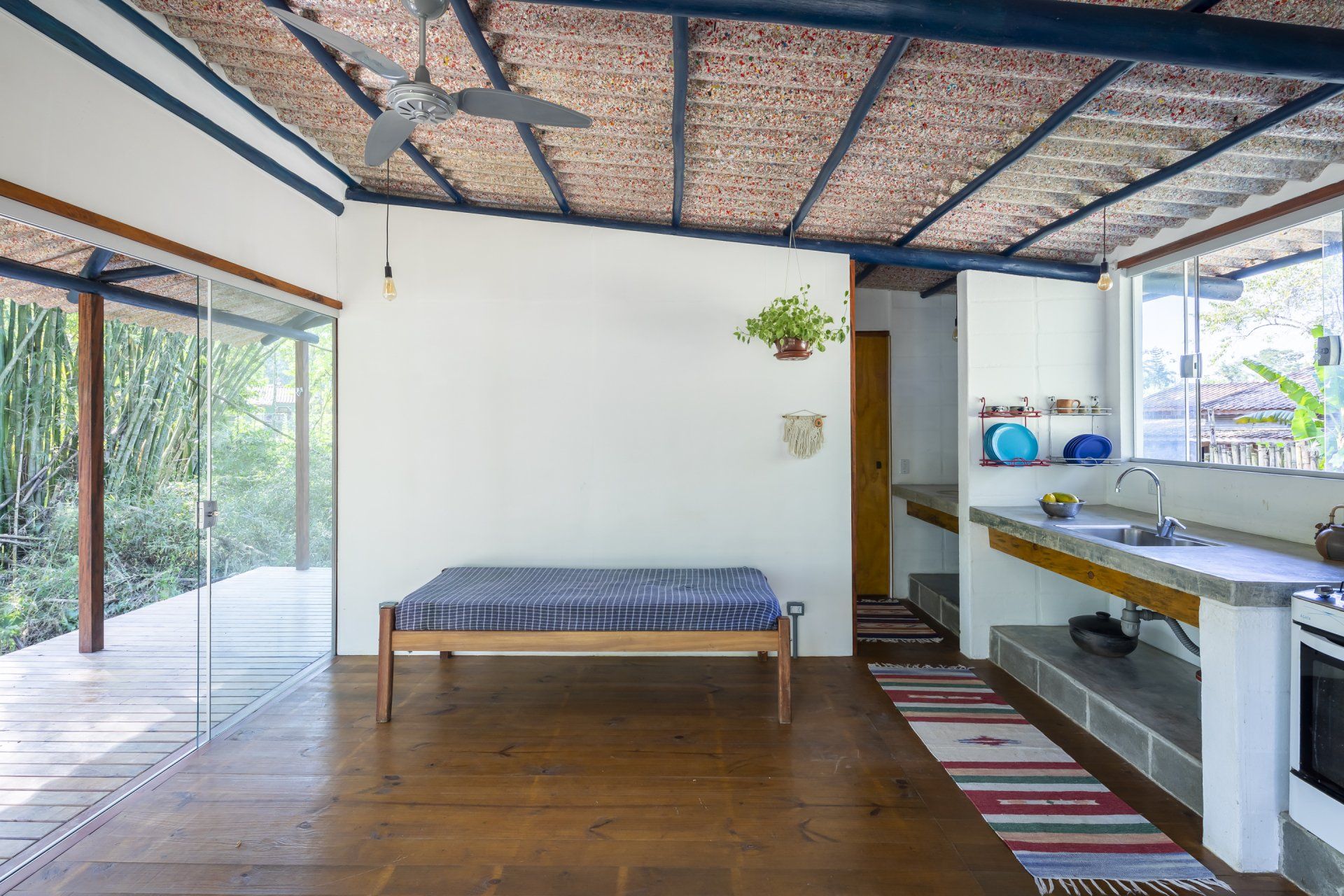 Tem uma bancada no meio da sala com ventilador de teto.