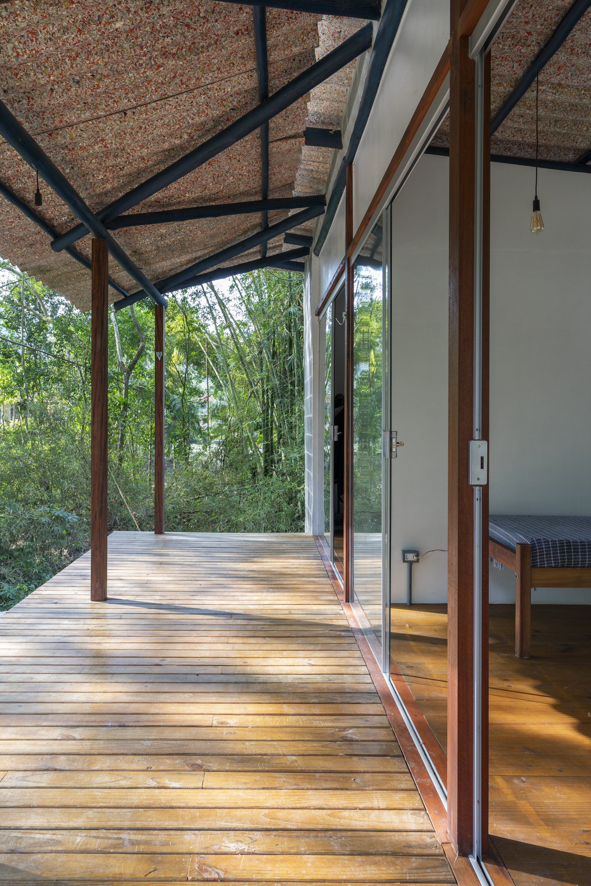 Um deck de madeira com porta de correr de vidro que dá acesso a um quarto.