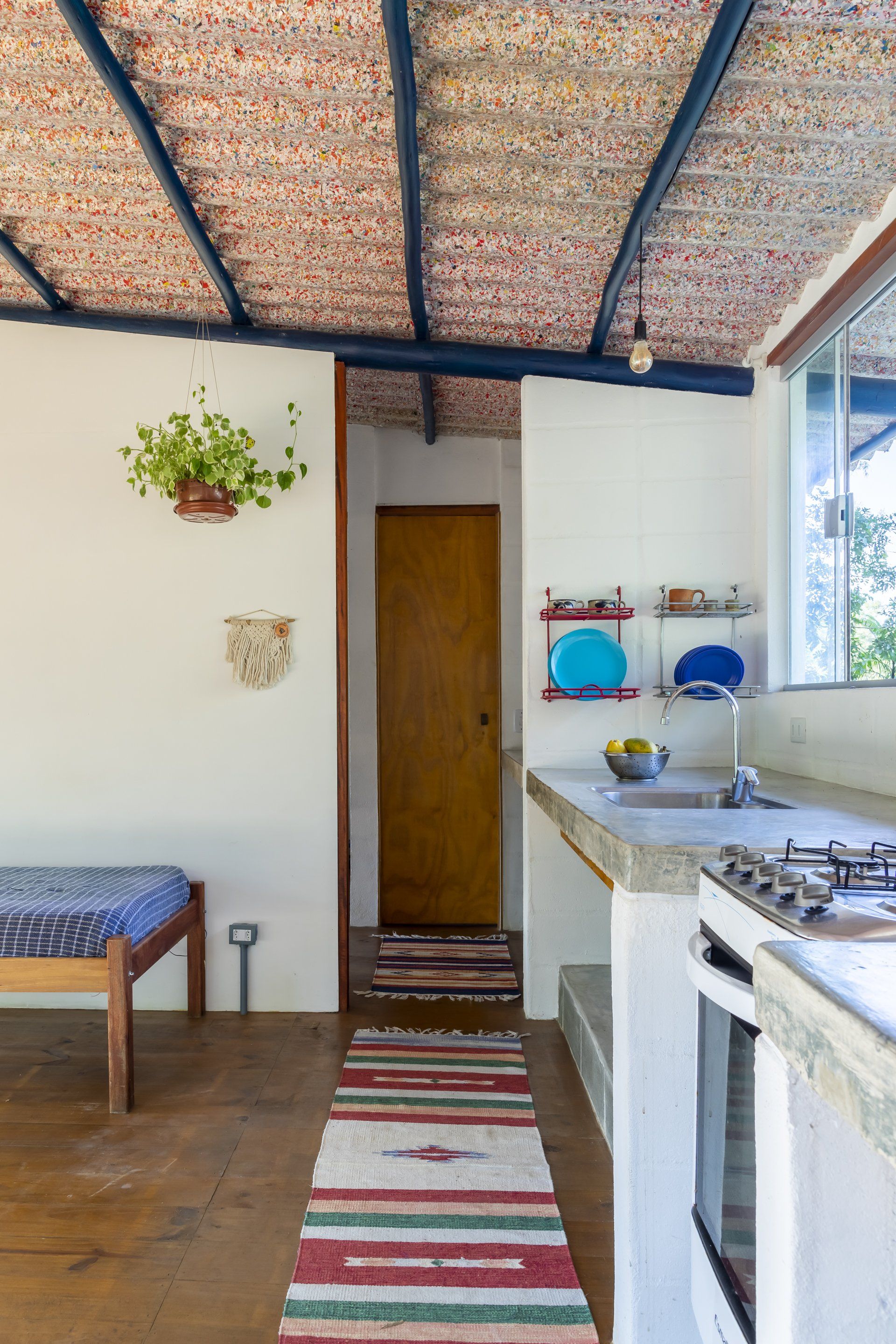Uma cozinha com fogão, pia e tapete.