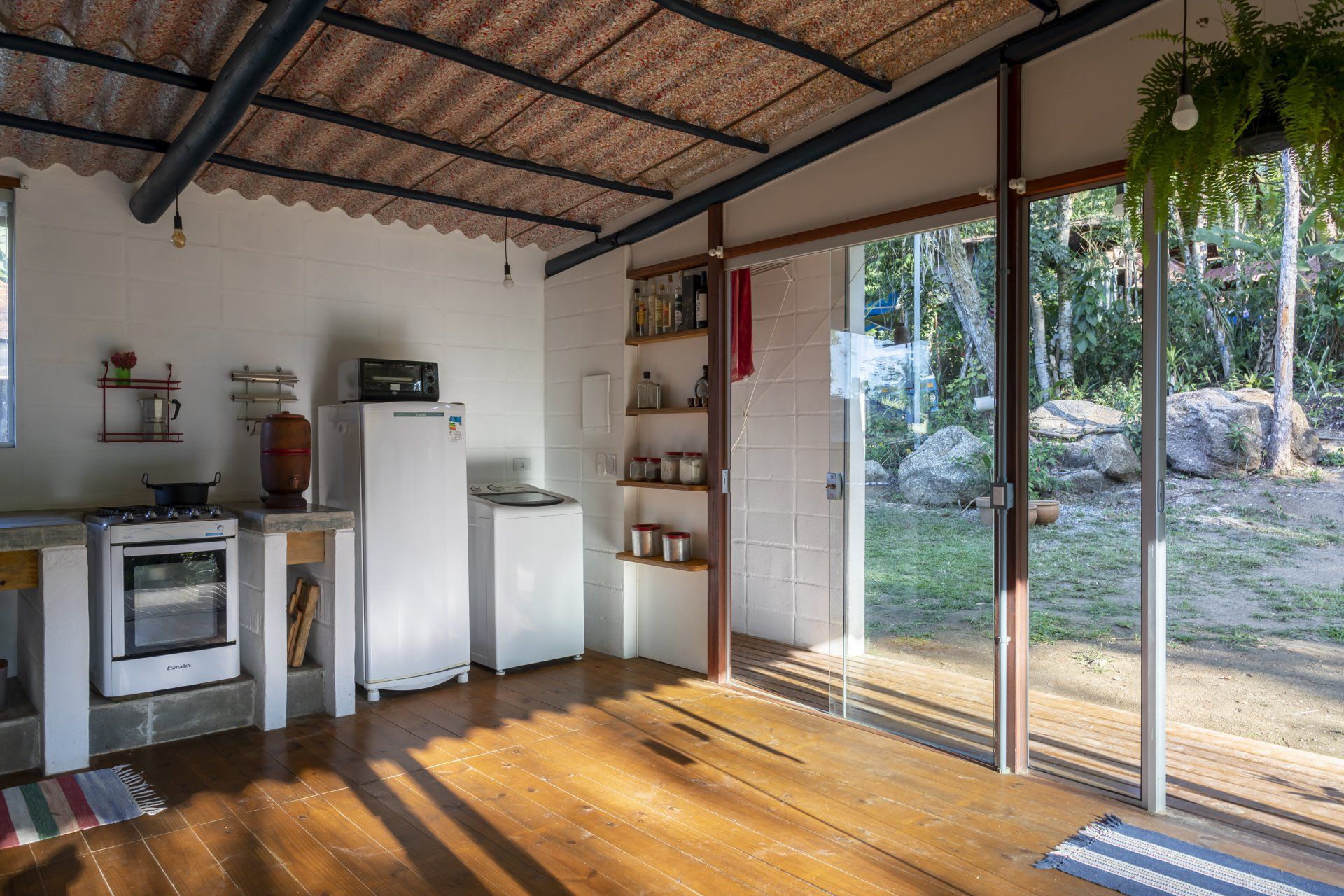 Uma cozinha com geladeira, fogão, forno e portas de correr de vidro.