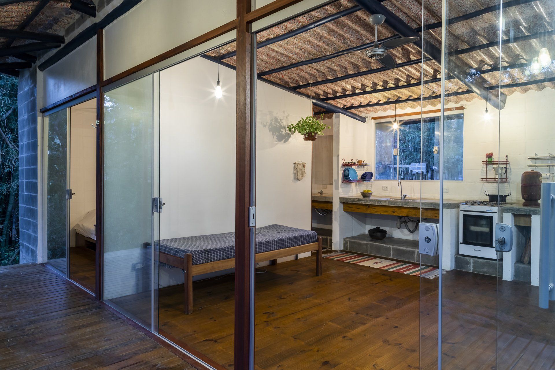 Um quarto com cama e cozinha com portas de correr de vidro.