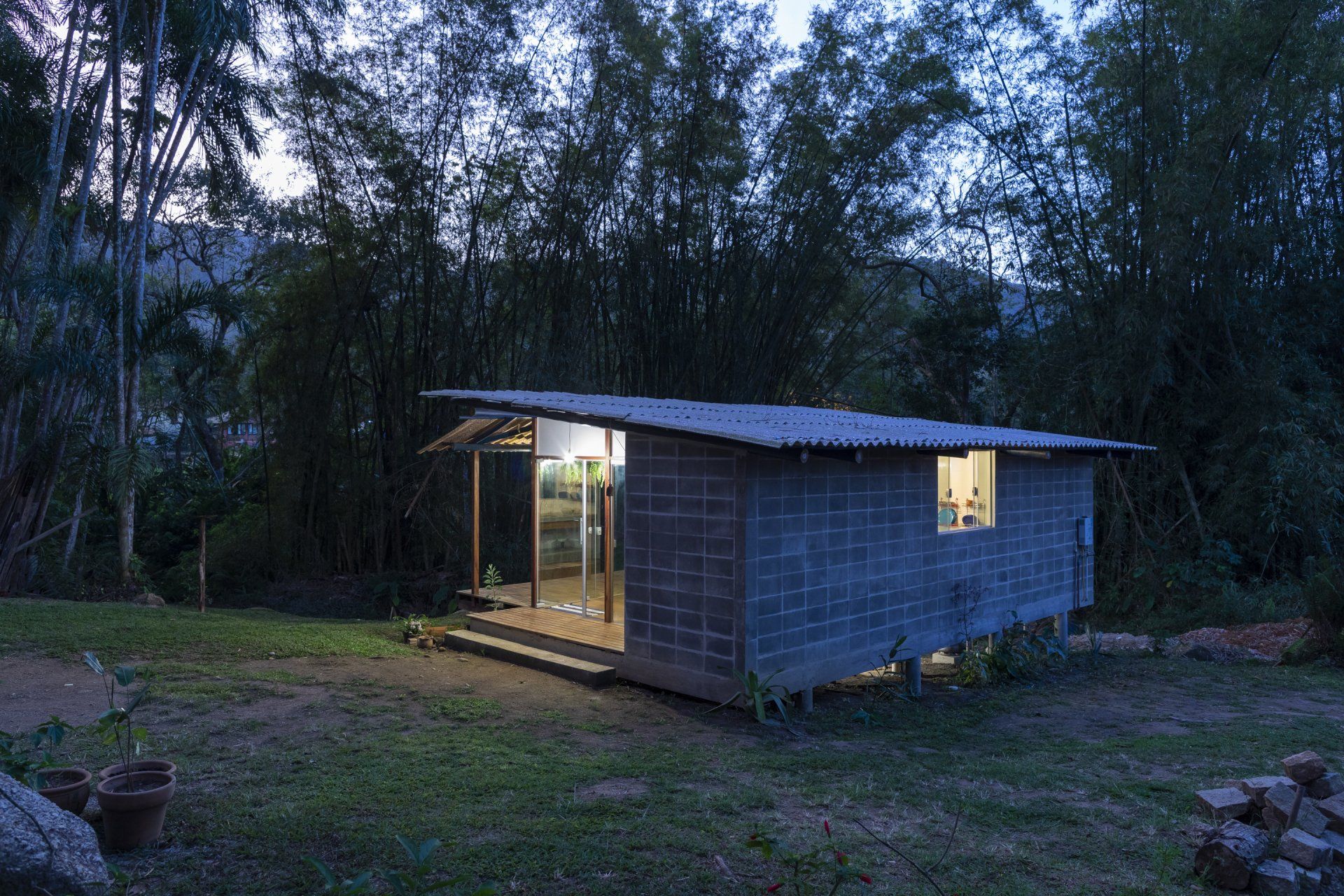 Uma pequena casa está situada no meio de uma floresta.