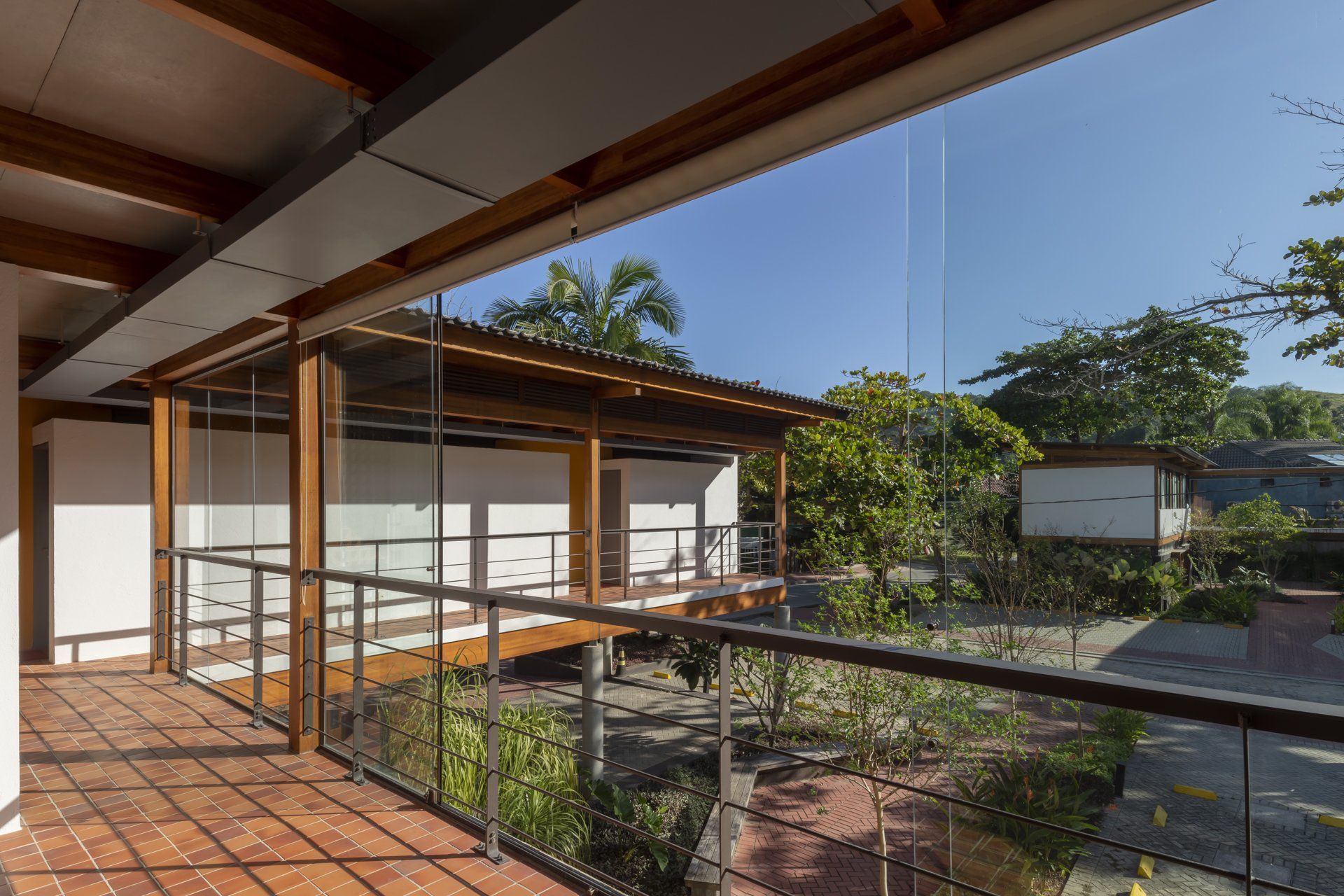 Uma varanda com grade de vidro e telhado de madeira.