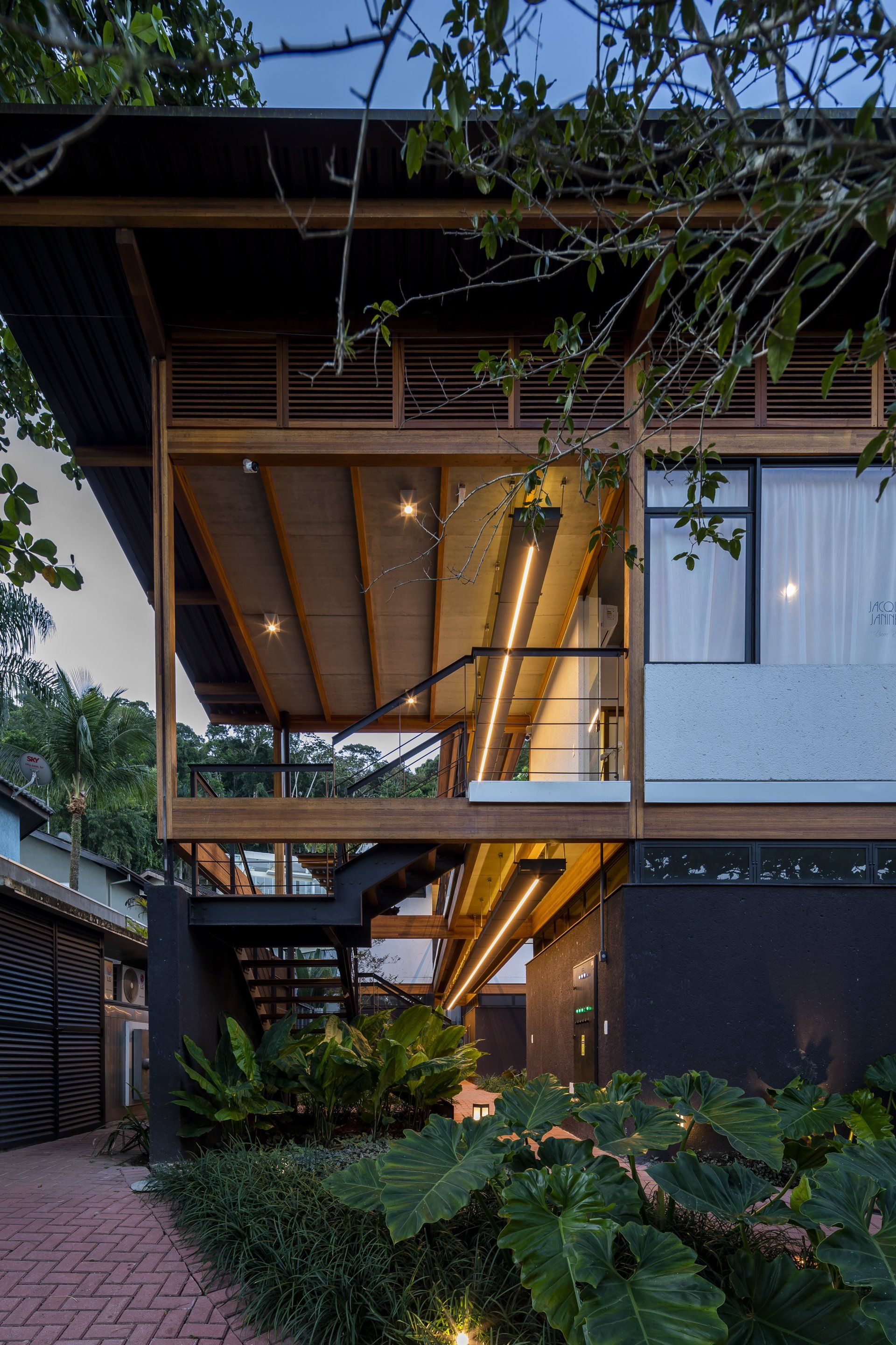 Uma grande casa de madeira com uma escada que dá acesso ao segundo andar.