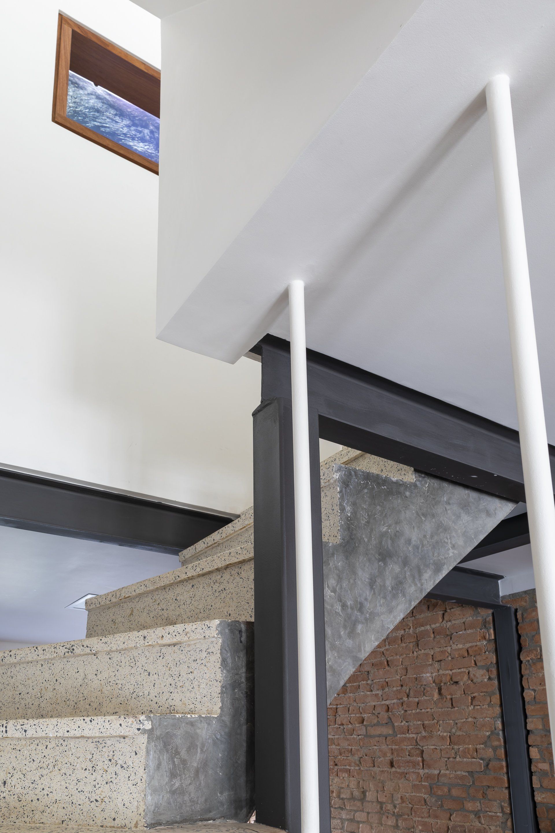 Uma escada com parede de tijolos e corrimão branco