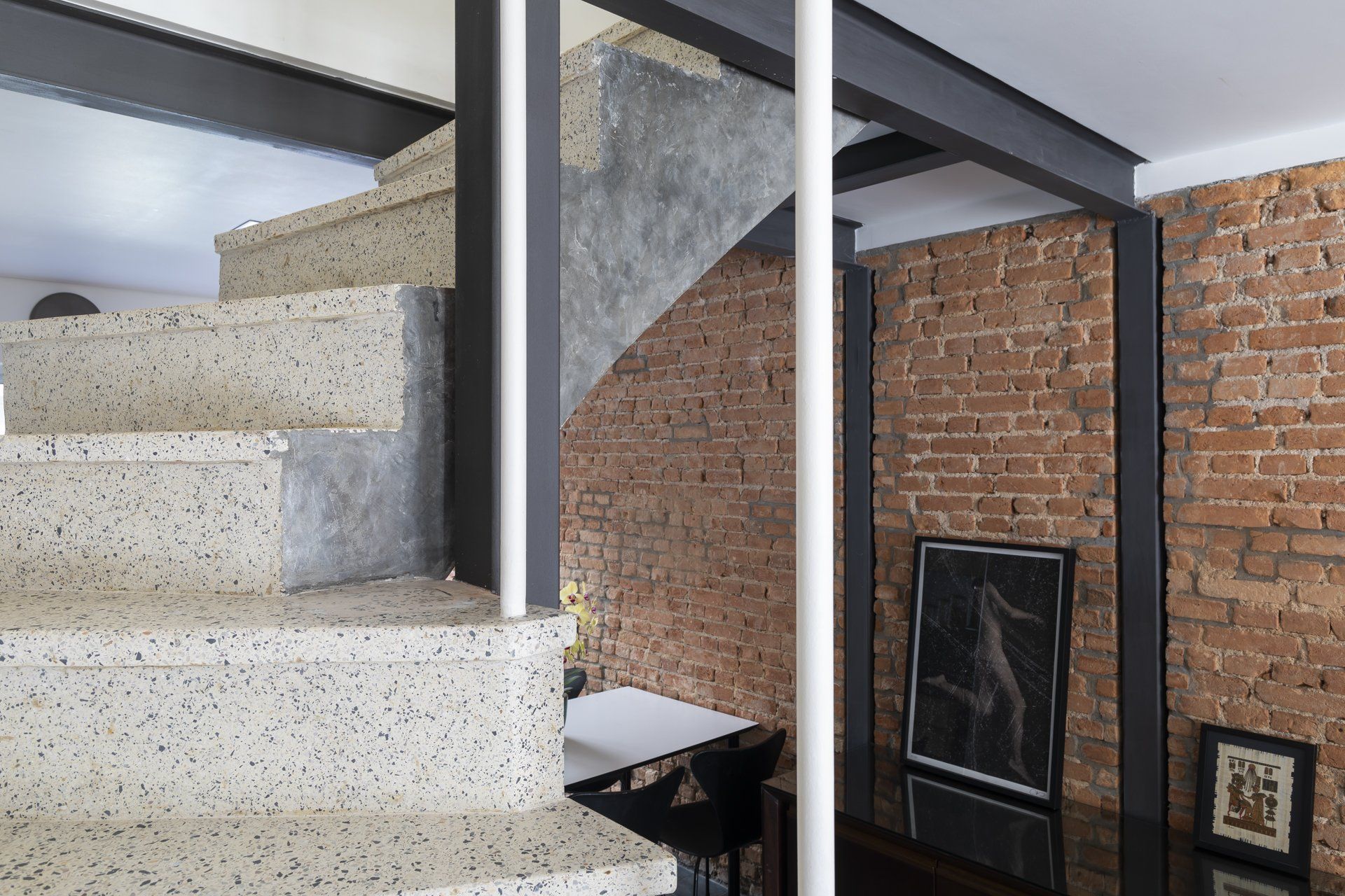 Uma escada que leva ao segundo andar de uma casa com parede de tijolos.