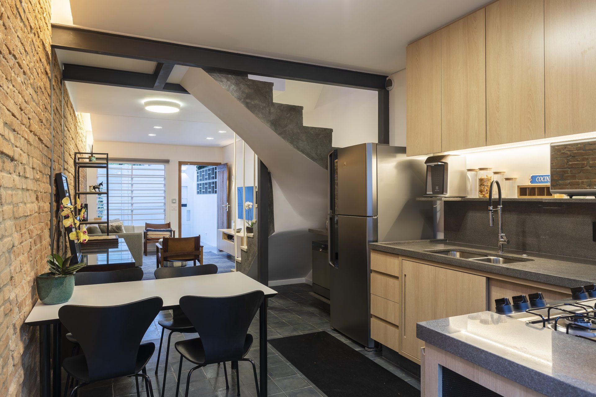 Uma cozinha com mesa e cadeiras e geladeira.