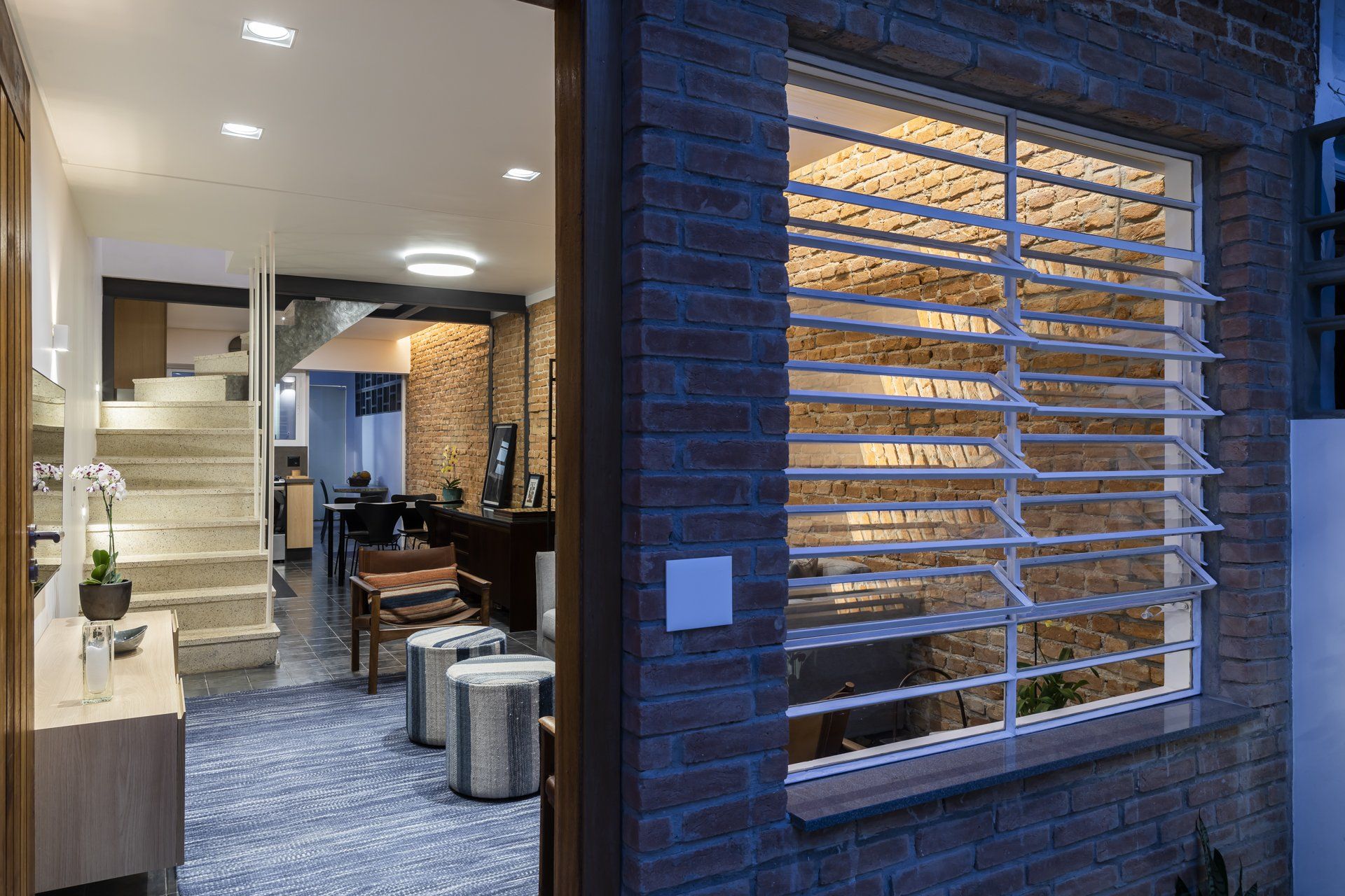 Um prédio de tijolos com uma janela e escadas ao fundo.