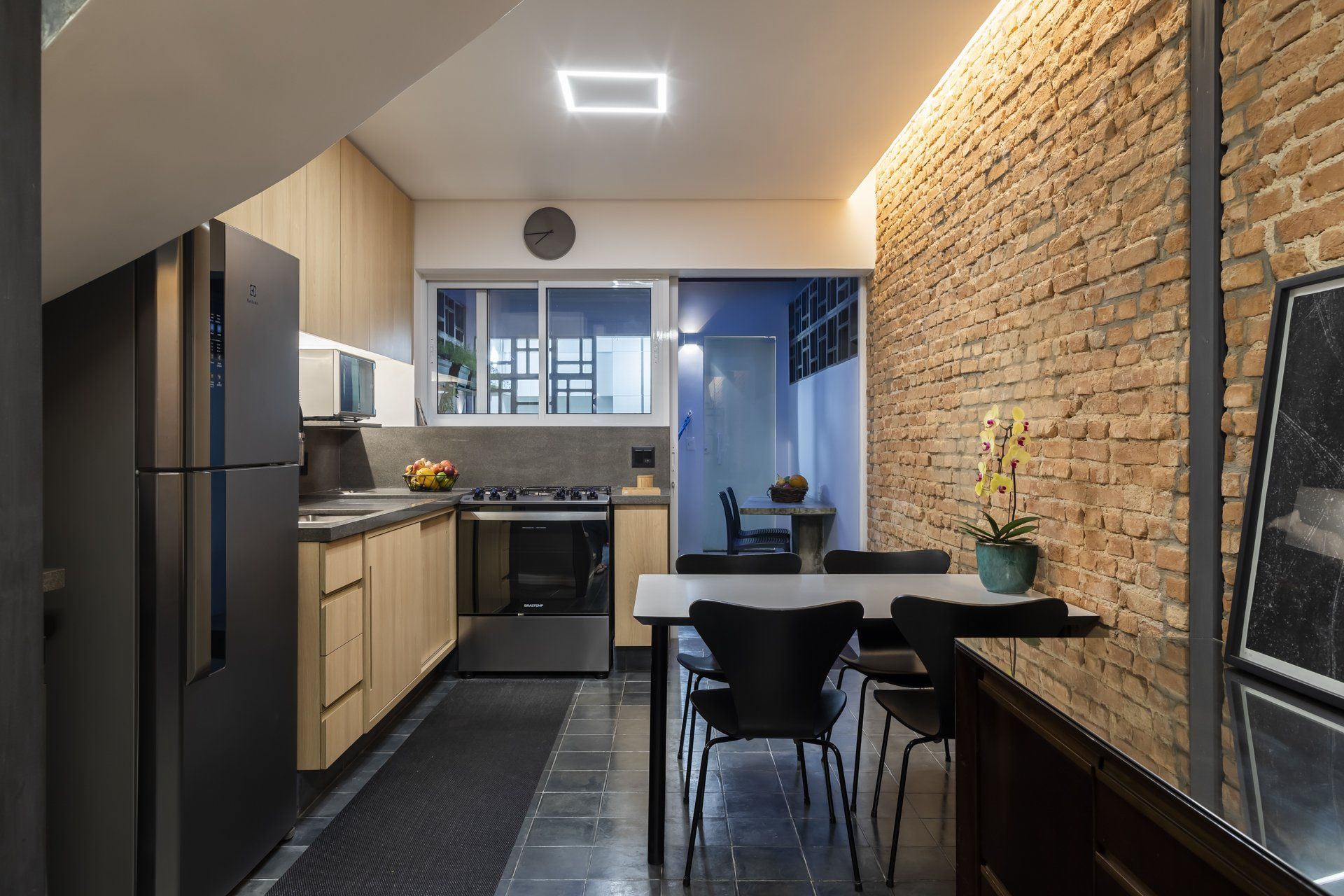 Uma cozinha com mesa e cadeiras e parede de tijolos.