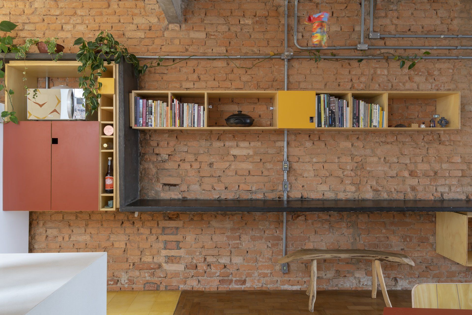 Uma sala de estar com parede de tijolos e uma estante com livros.