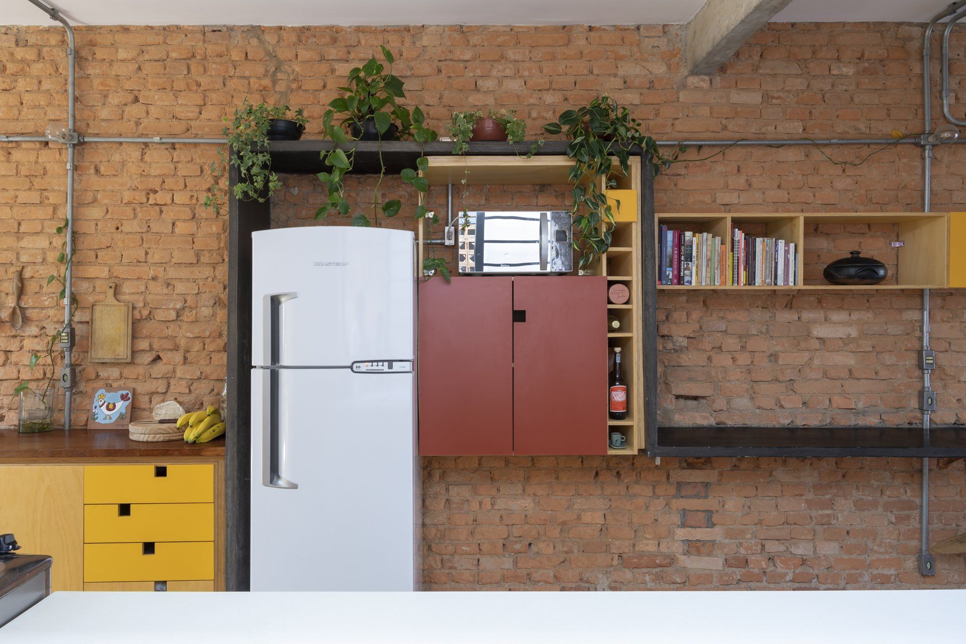 Uma cozinha com geladeira branca e parede de tijolos