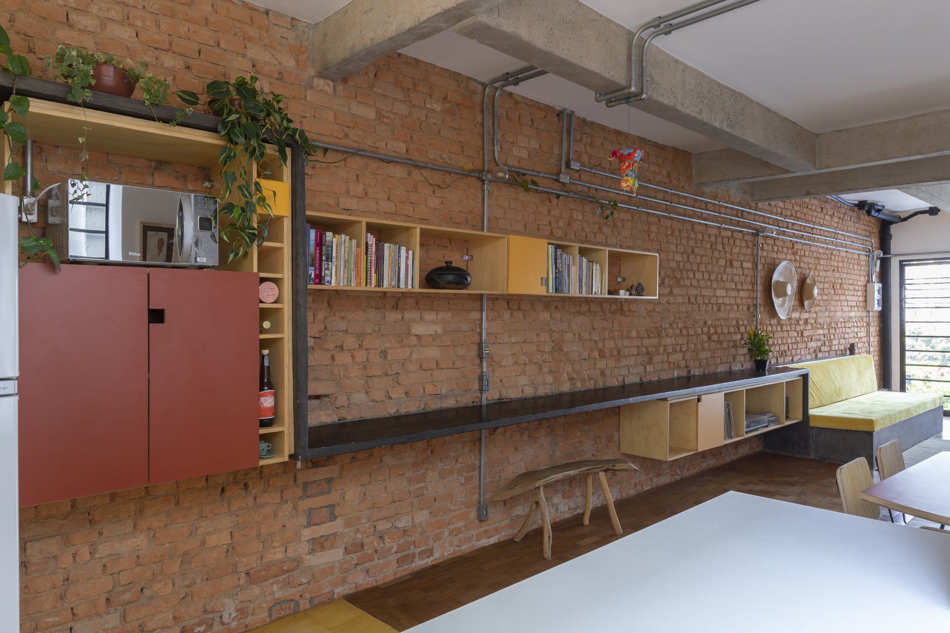 Uma sala com parede de tijolos e uma mesa.