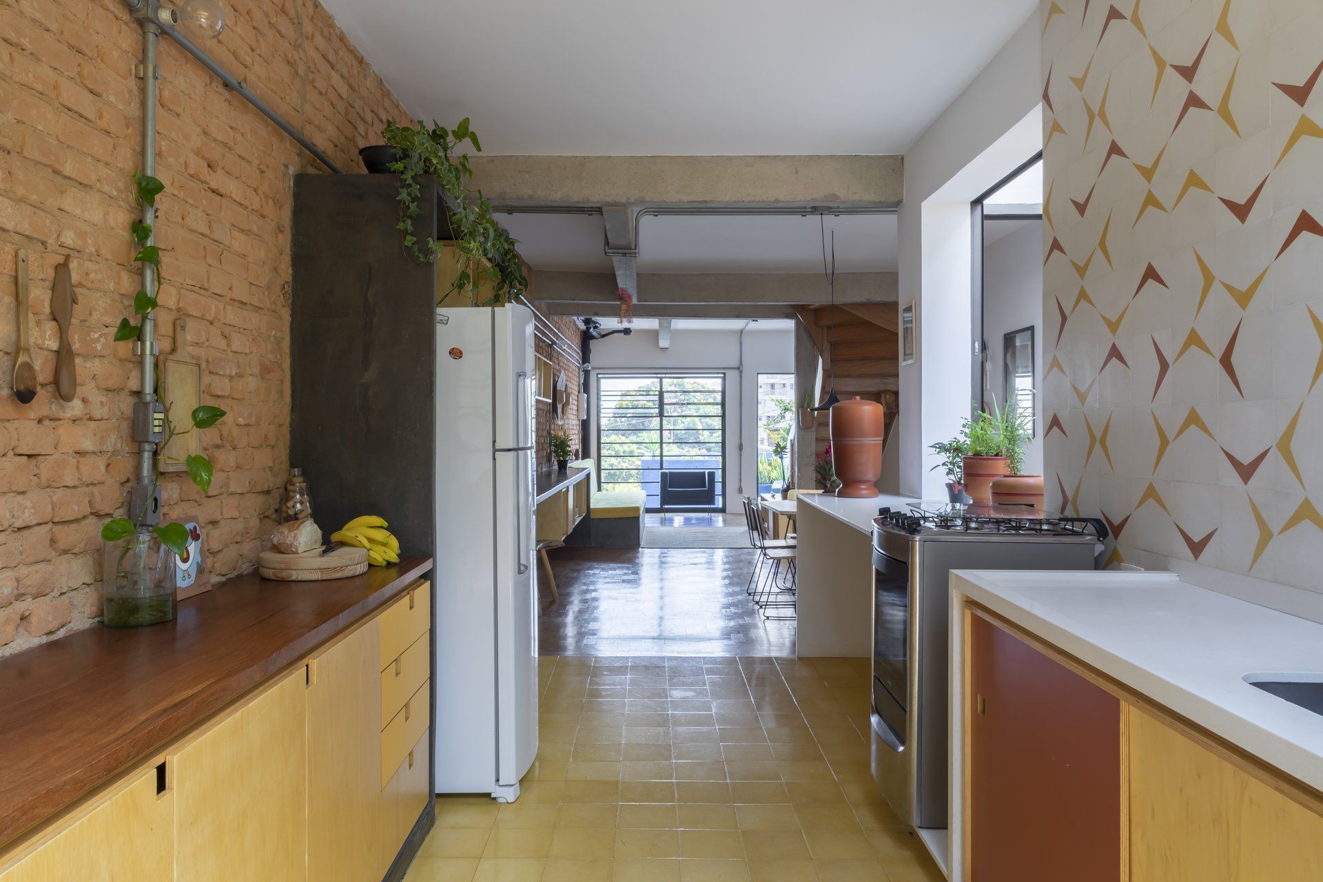 Uma cozinha com geladeira, fogão e pia.