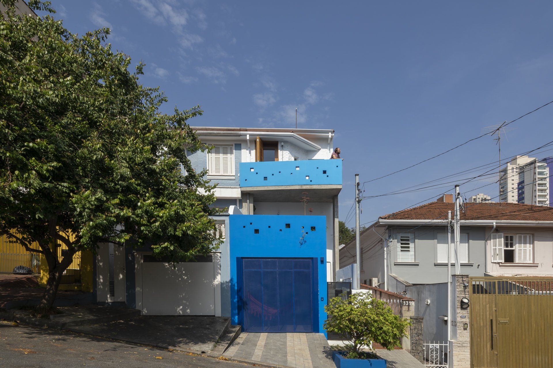 Uma casa azul e branca com porta de garagem azul