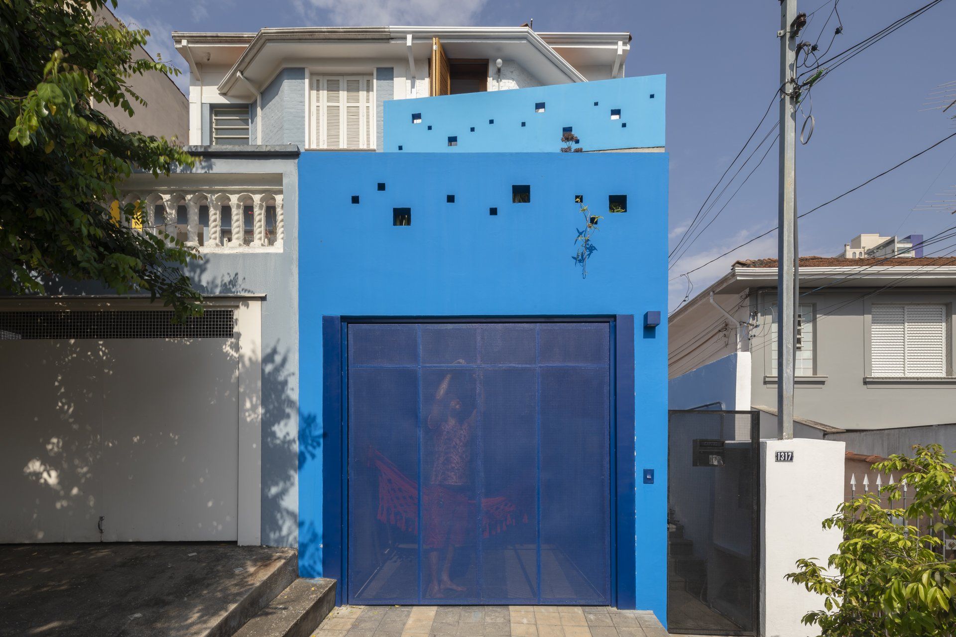 A frente de uma casa azul com porta de garagem azul