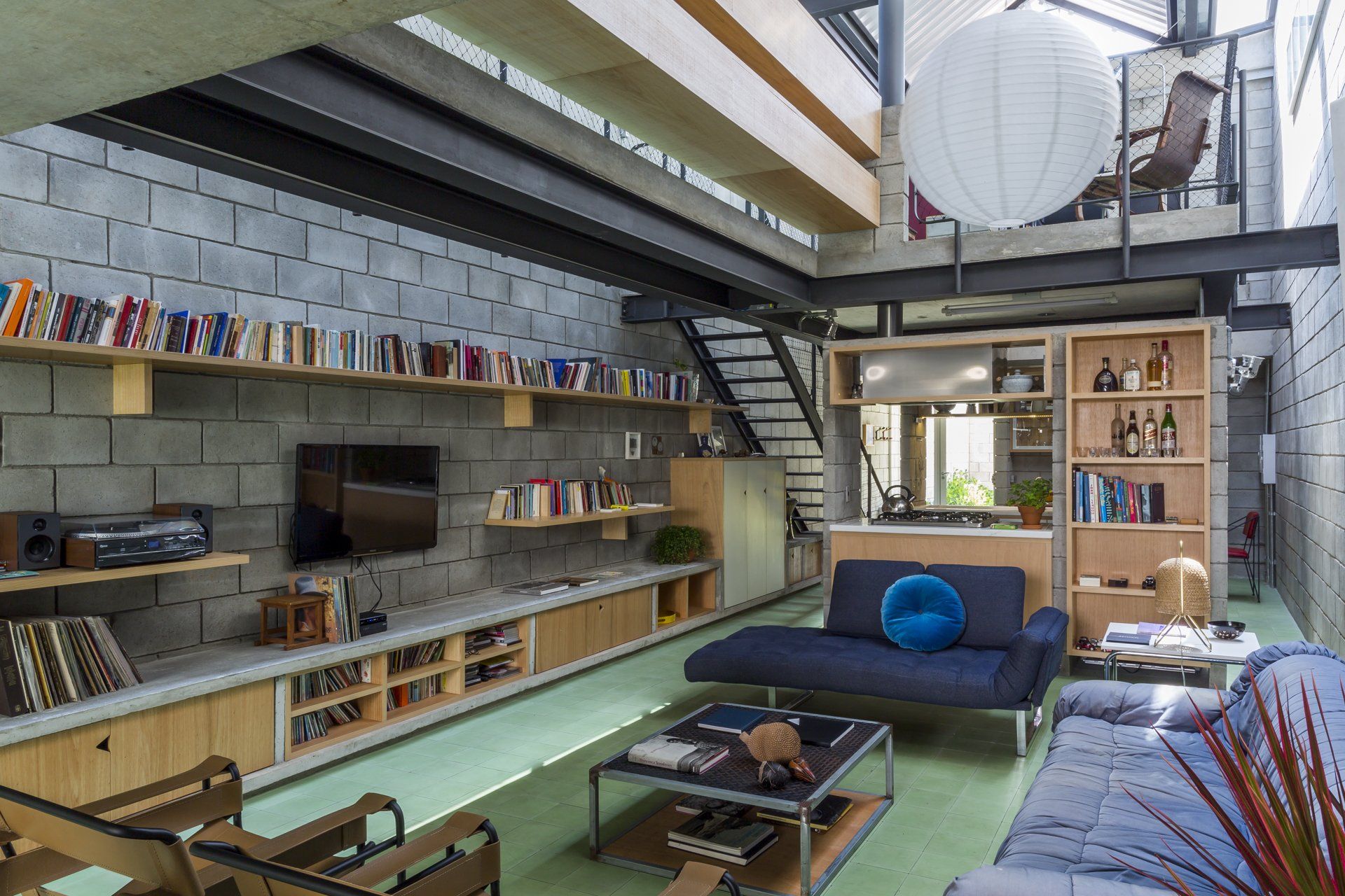 Uma sala com sofá, mesa, cadeiras e televisão.