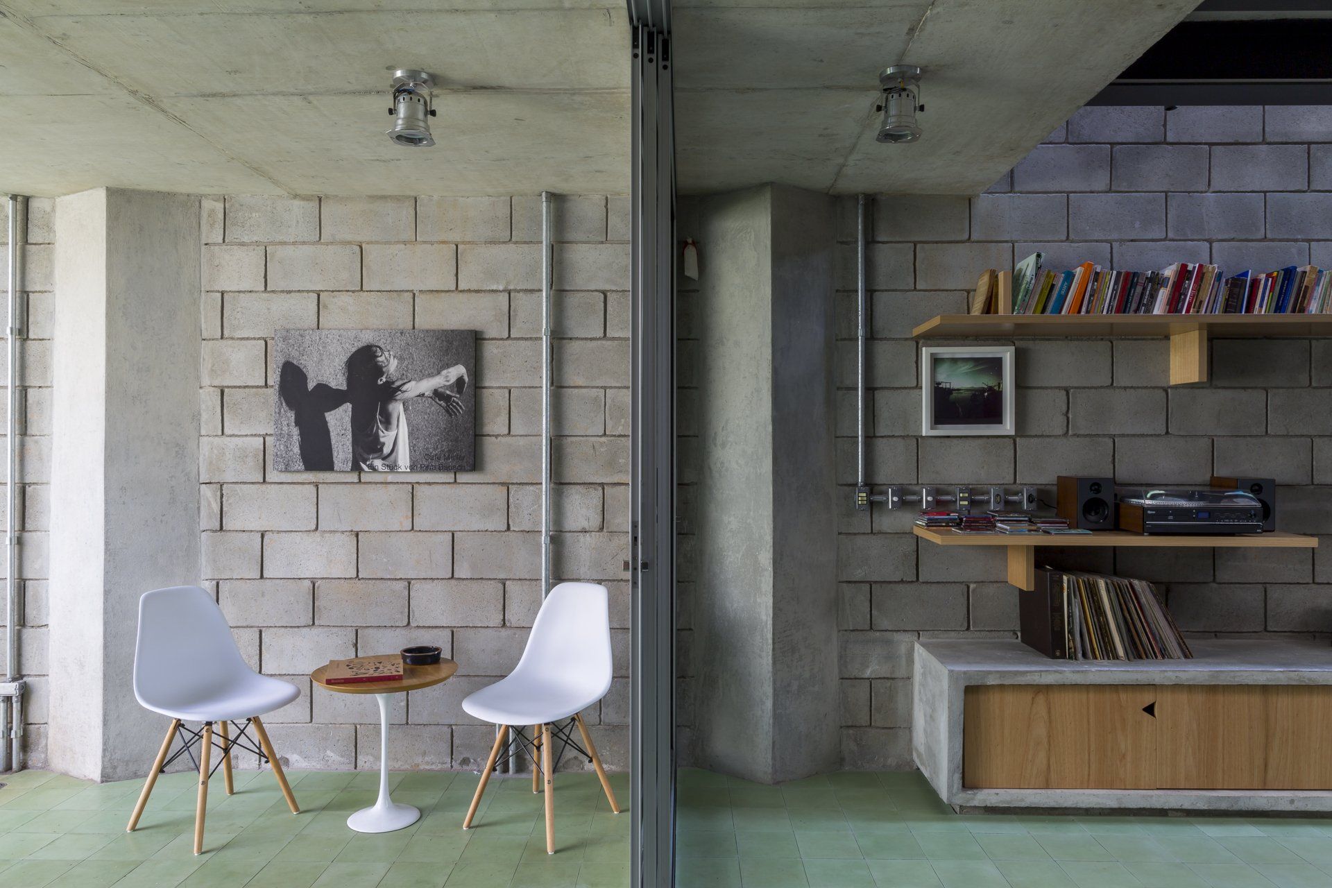 Uma sala com mesa e cadeiras e um quadro na parede.