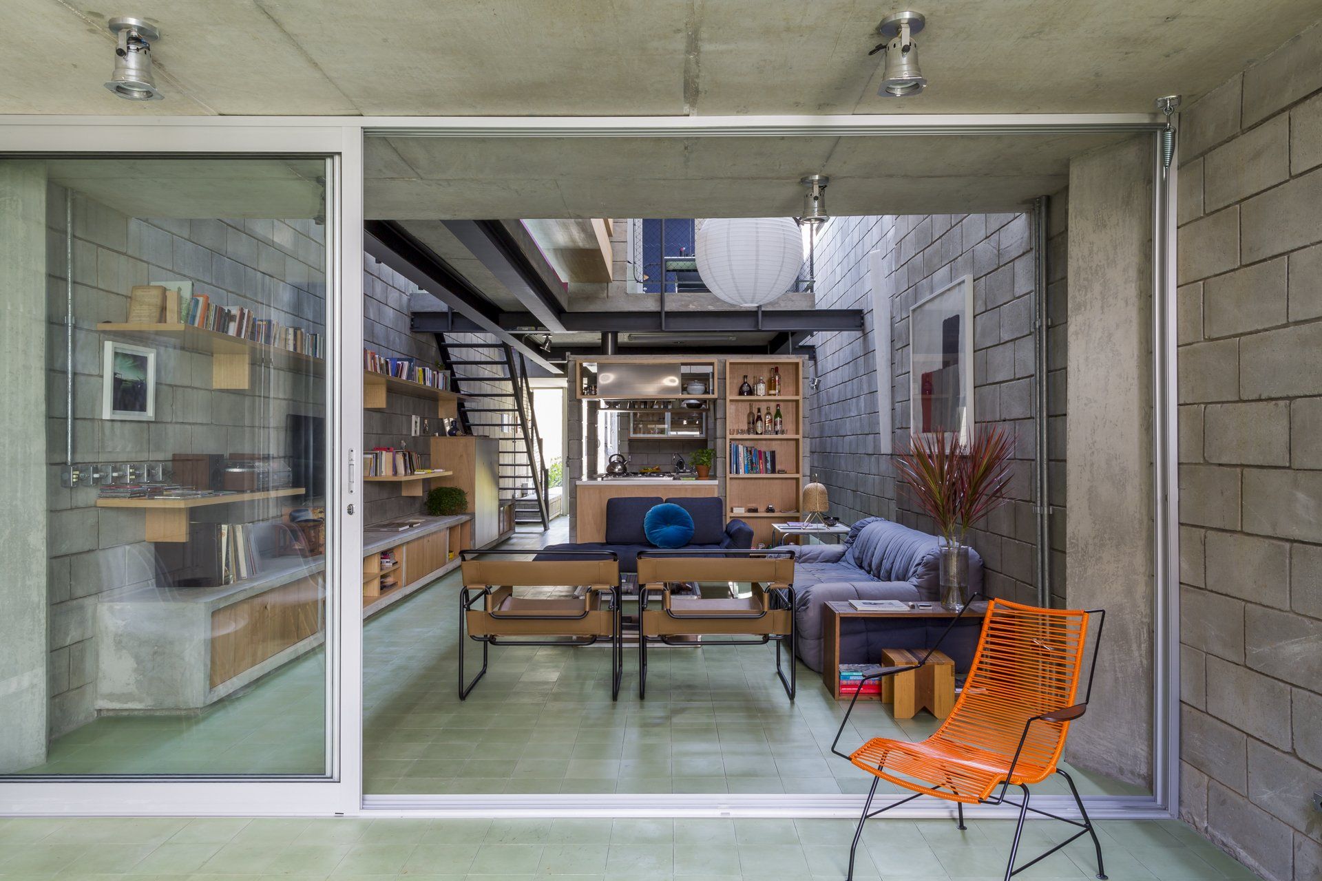 Uma sala de estar com porta de vidro deslizante e uma cadeira.