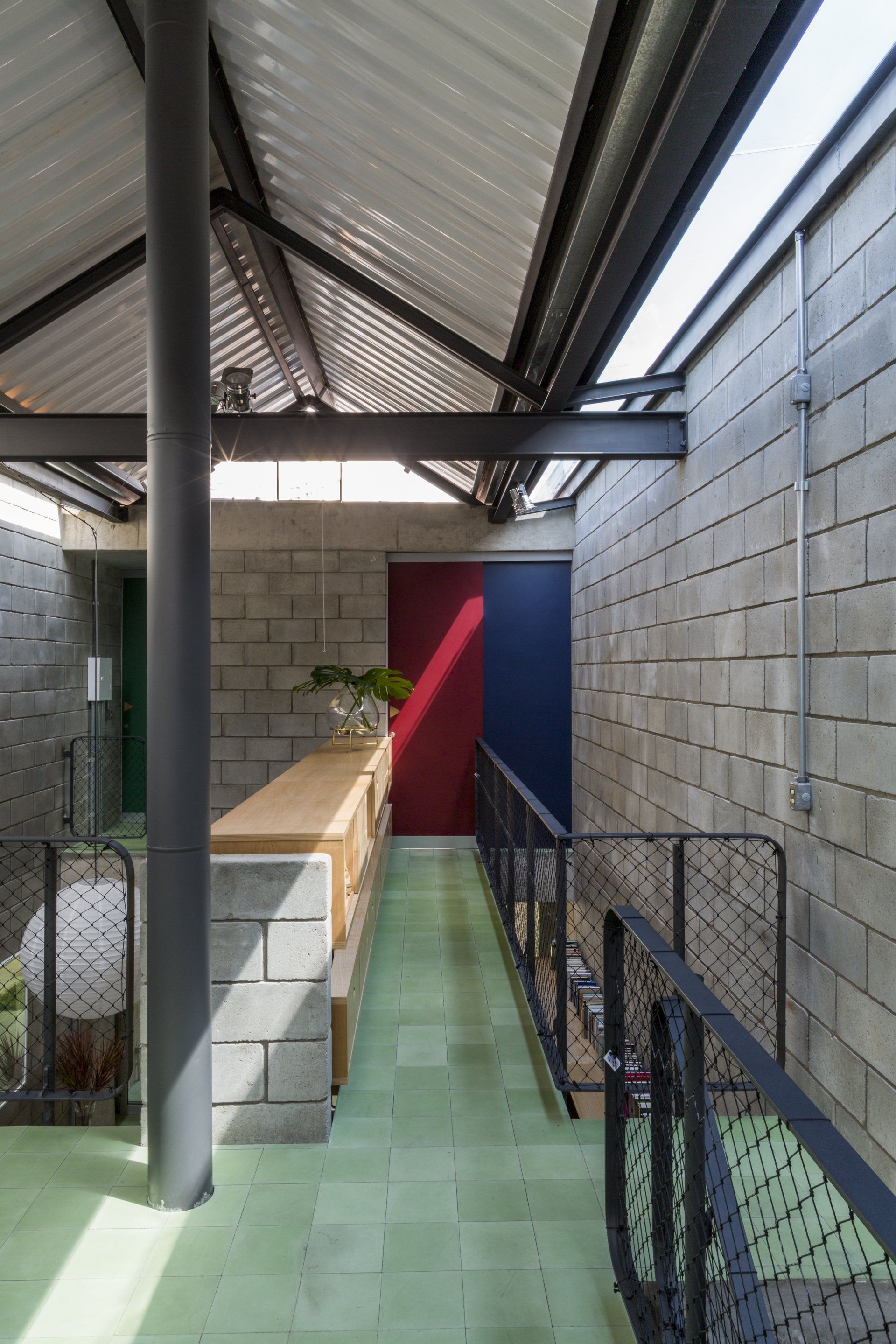 Um longo corredor entre dois edifícios com telhado metálico.