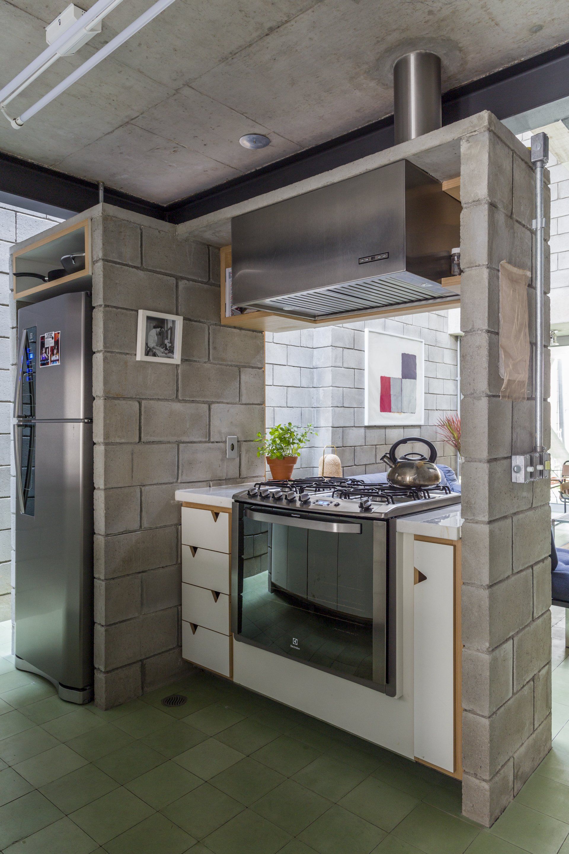 Uma cozinha com fogão, geladeira e pia.