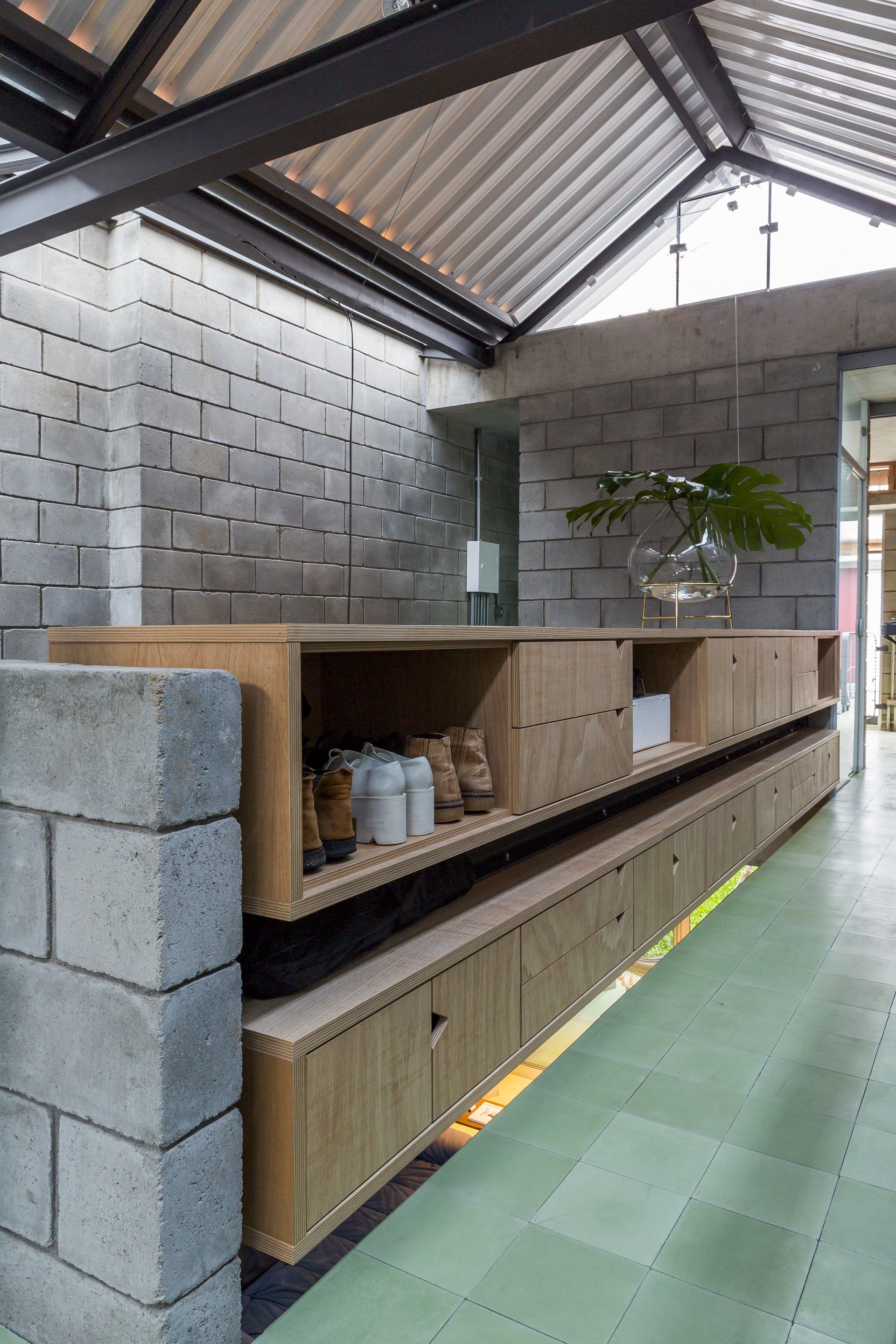 Uma sala com parede de tijolos e prateleiras de madeira.