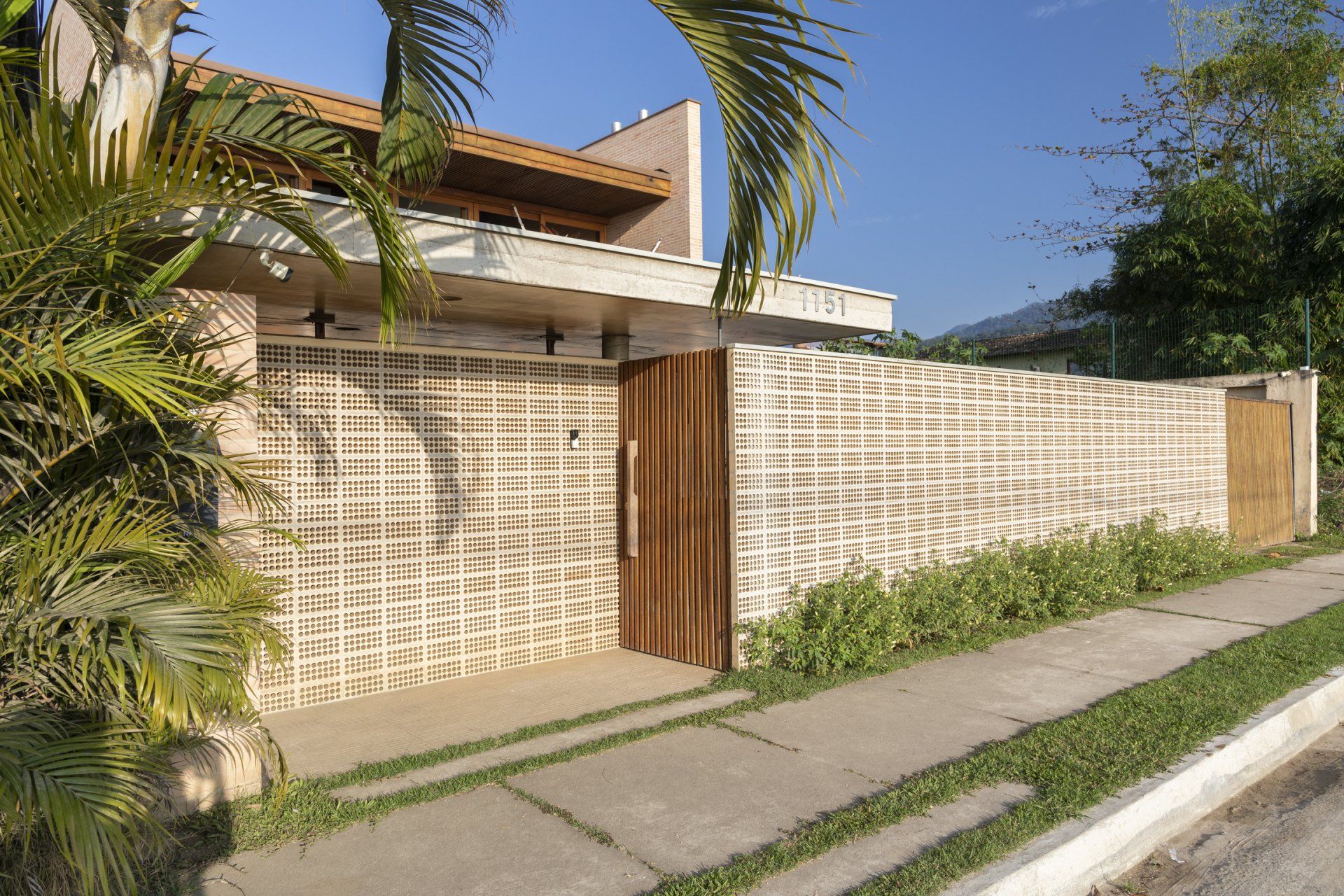 Uma casa com uma grande parede de tijolos e uma porta de madeira