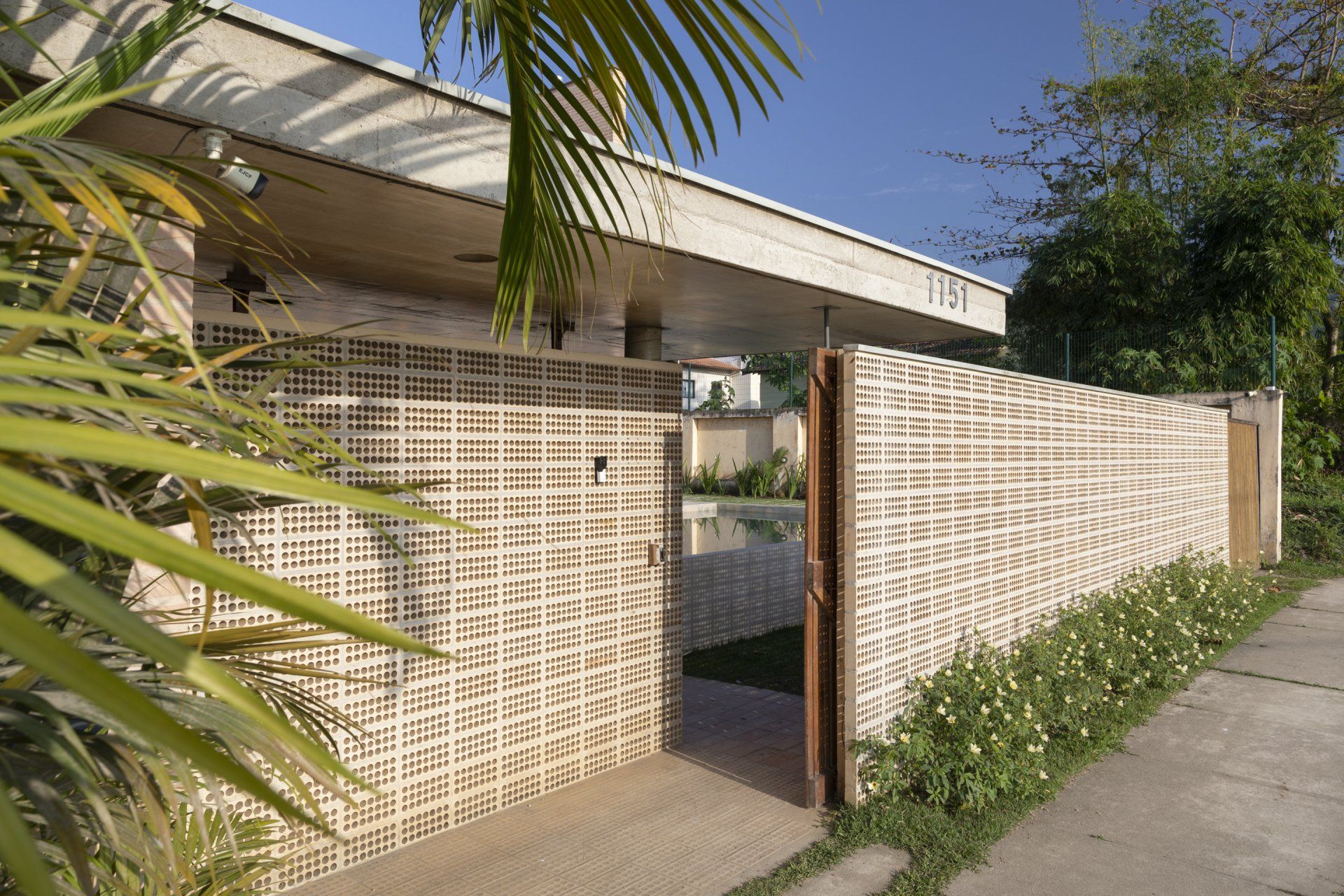 Uma casa com parede de tijolos e portão de madeira