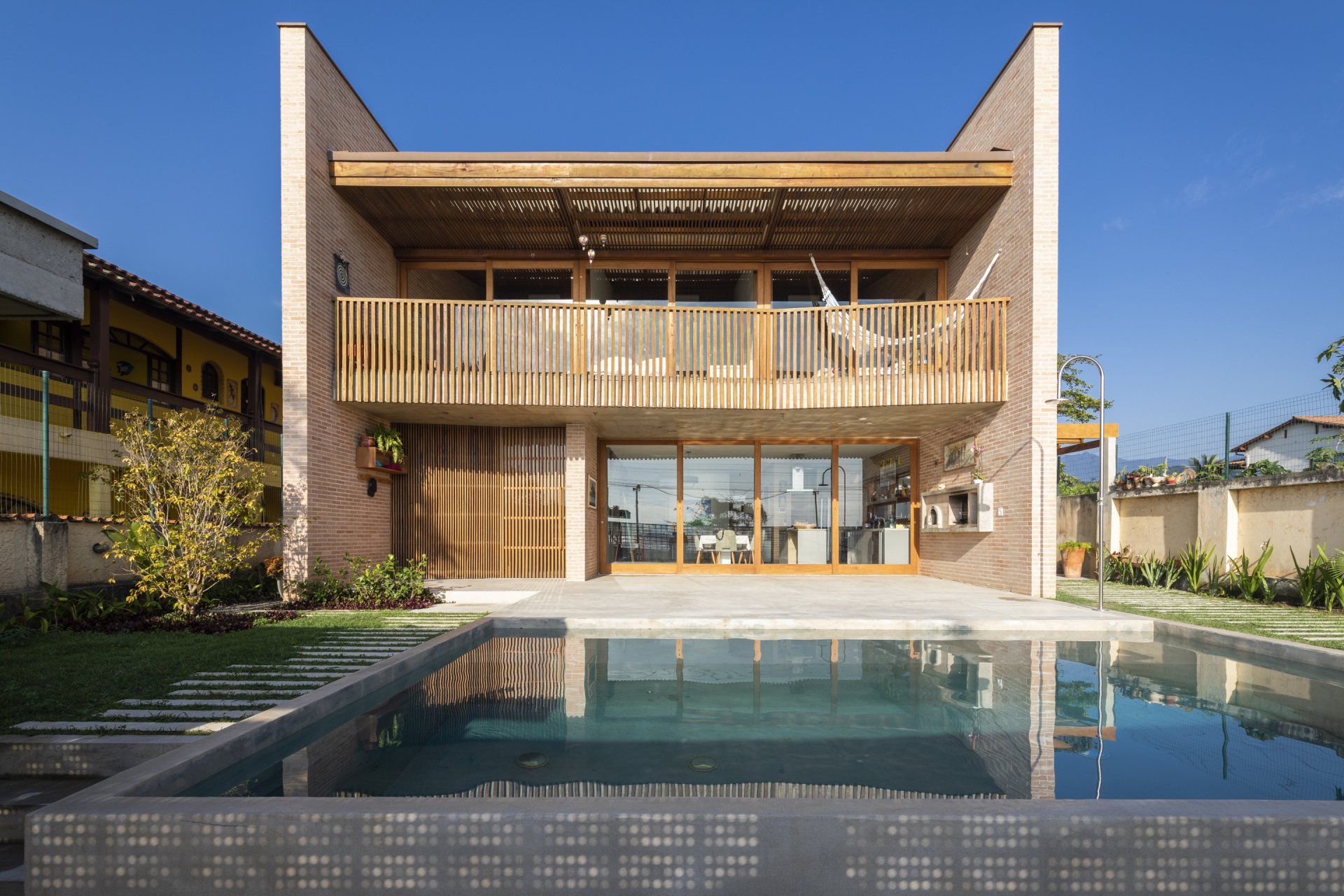 Uma casa grande com piscina em frente.