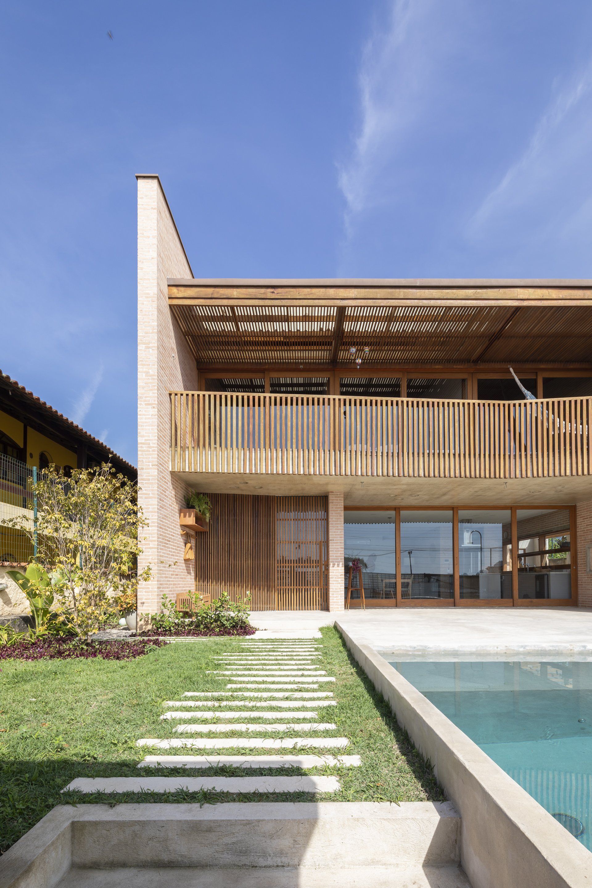 Uma casa grande com piscina em frente.