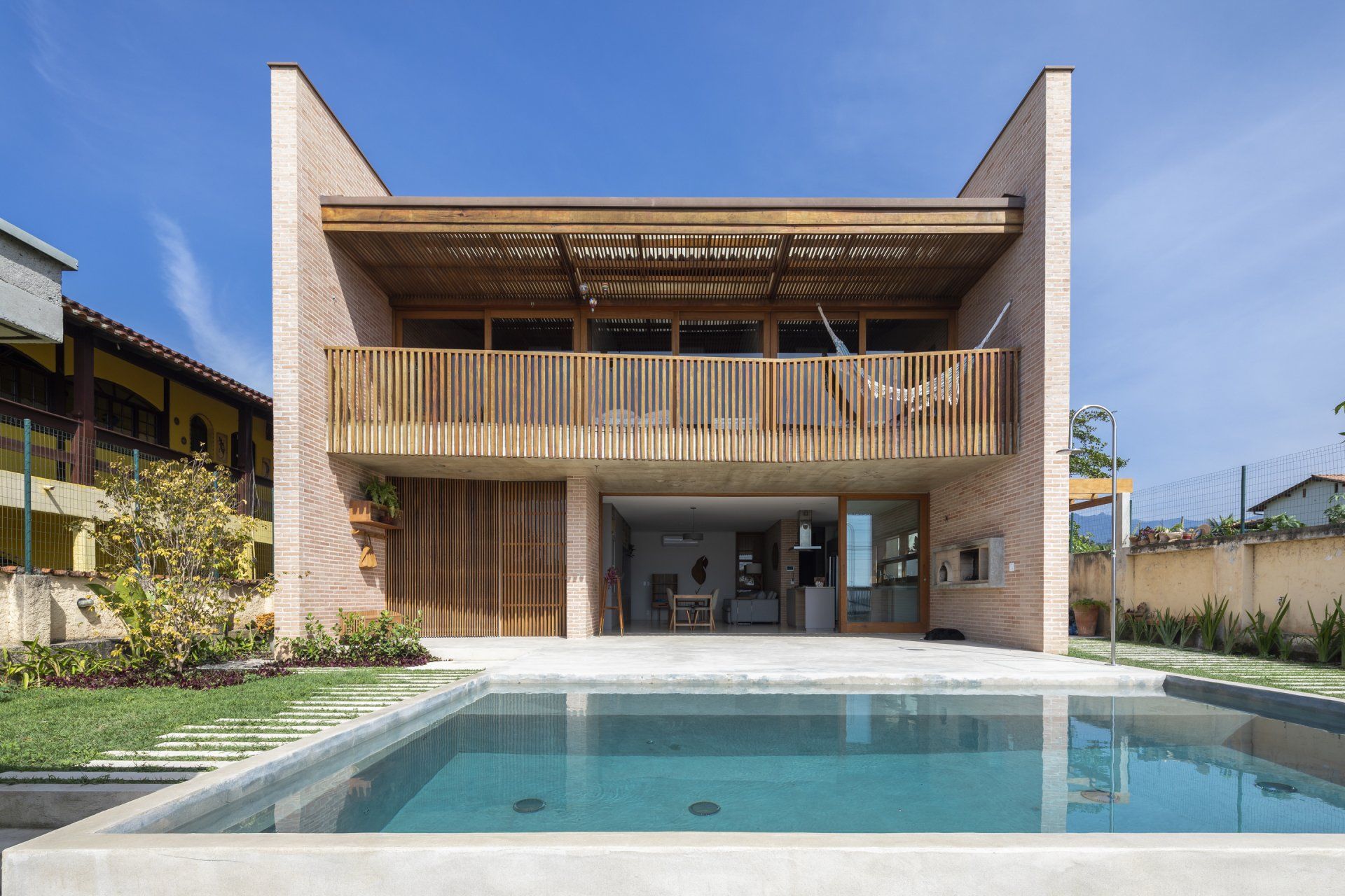 Uma casa grande com piscina em frente.